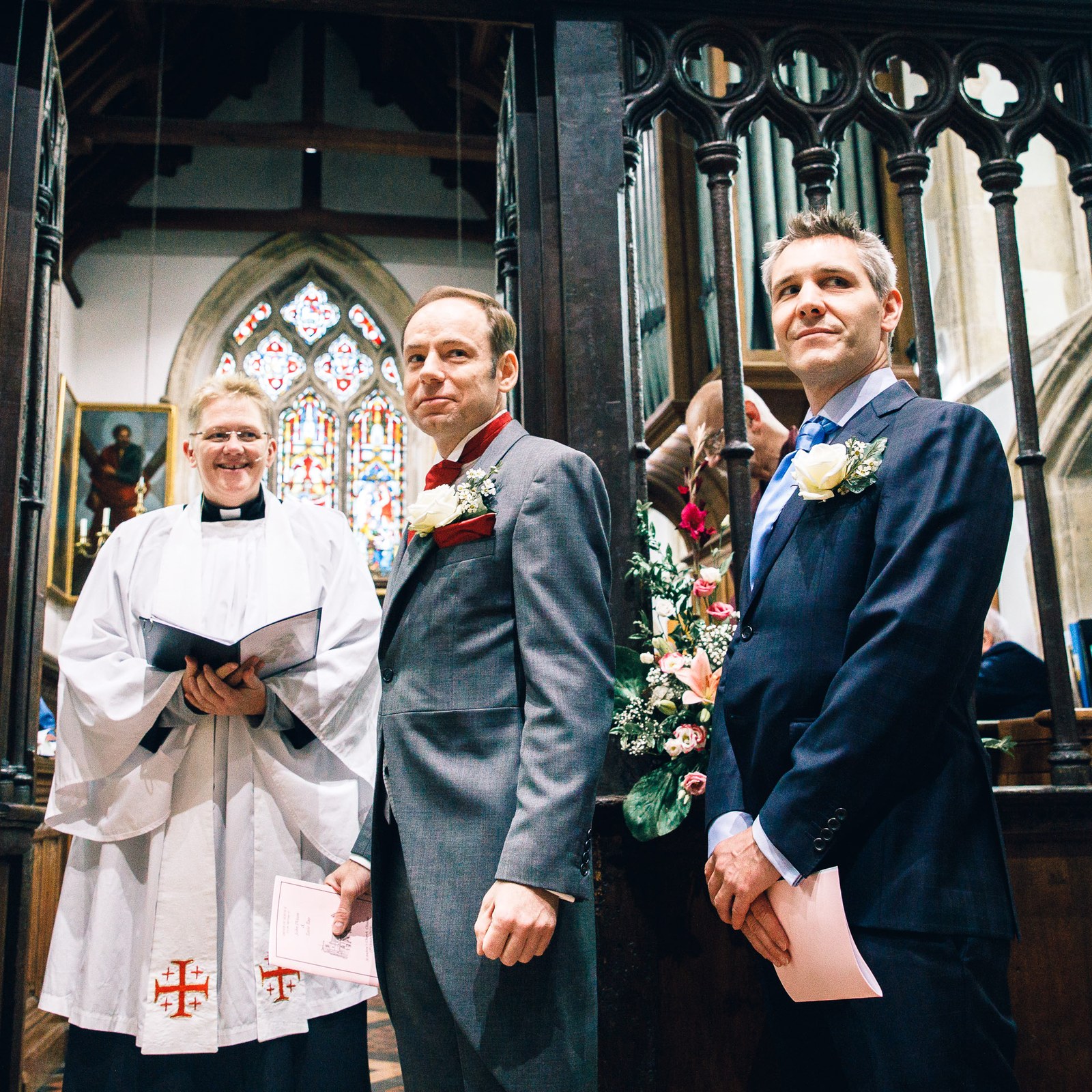 Groom and best man standing with the vicar at the front of the church