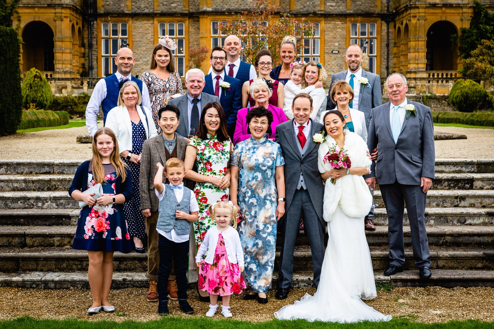 Family group photograph on the stone steps before the facade of Eynsham Hall