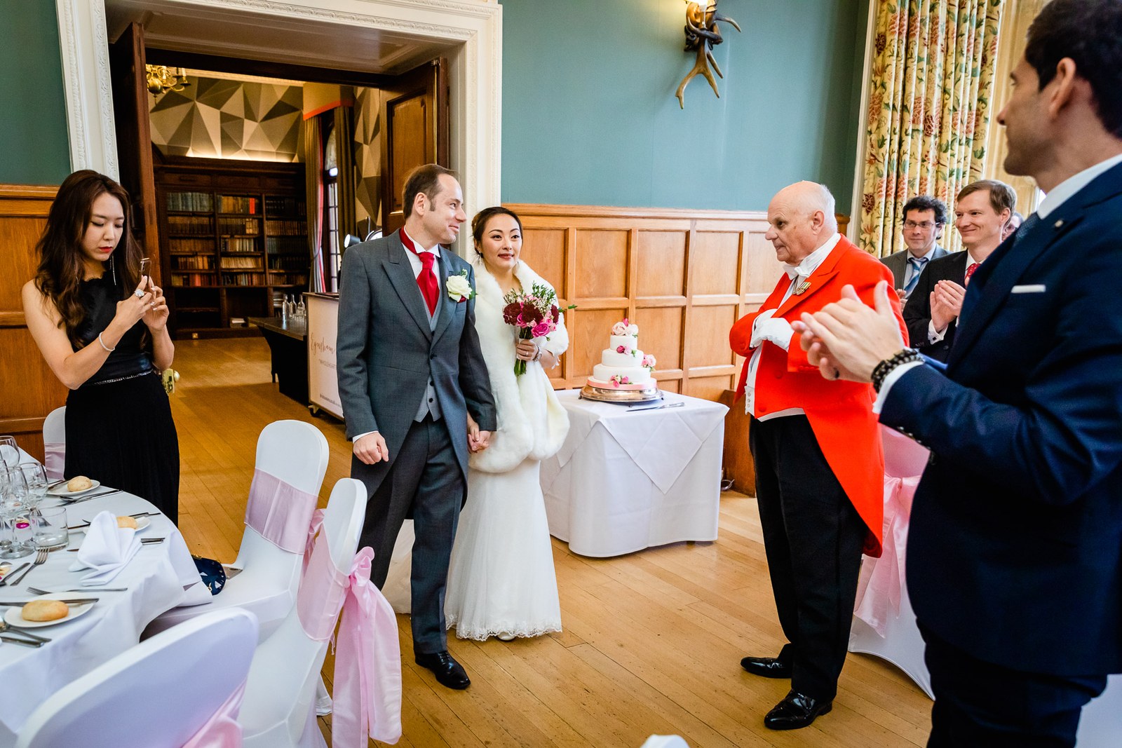 The toastmaster announcing the couple into the oak-panelled reception room at Eynsham Hall