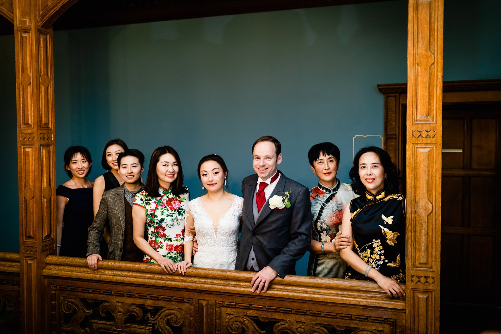 Family members gathered along a carved oak gallery at Eynsham Hall