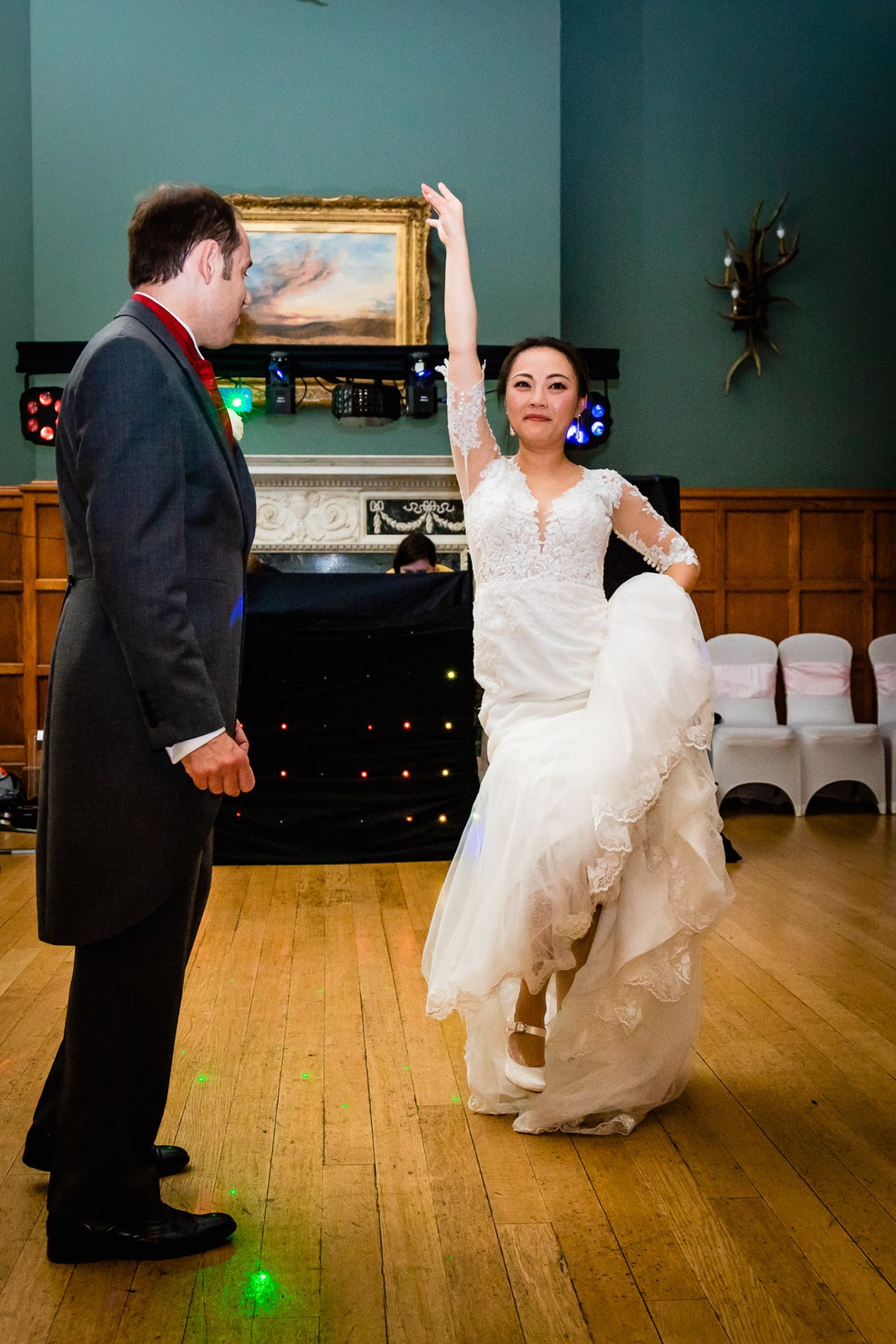 Bride twirling her skirt during the first dance in the panelled hall at Eynsham Hall