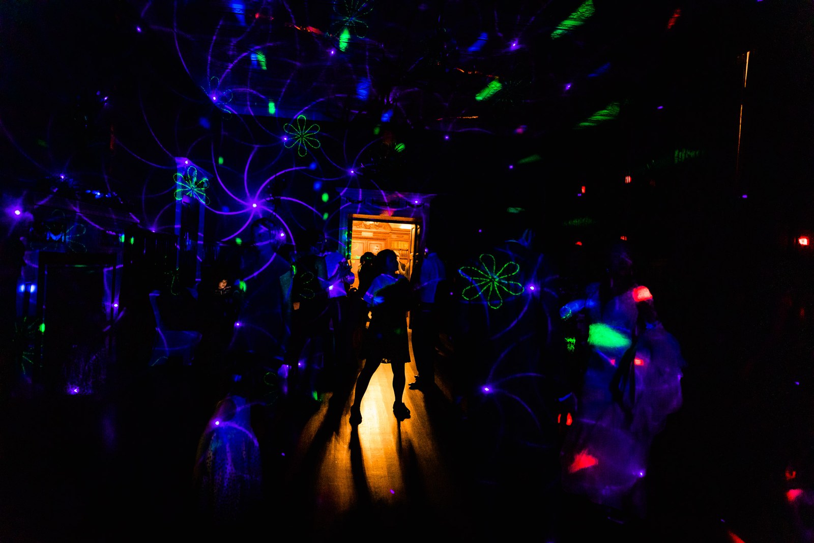 The couple silhouetted on the dance floor among blue and green lasers