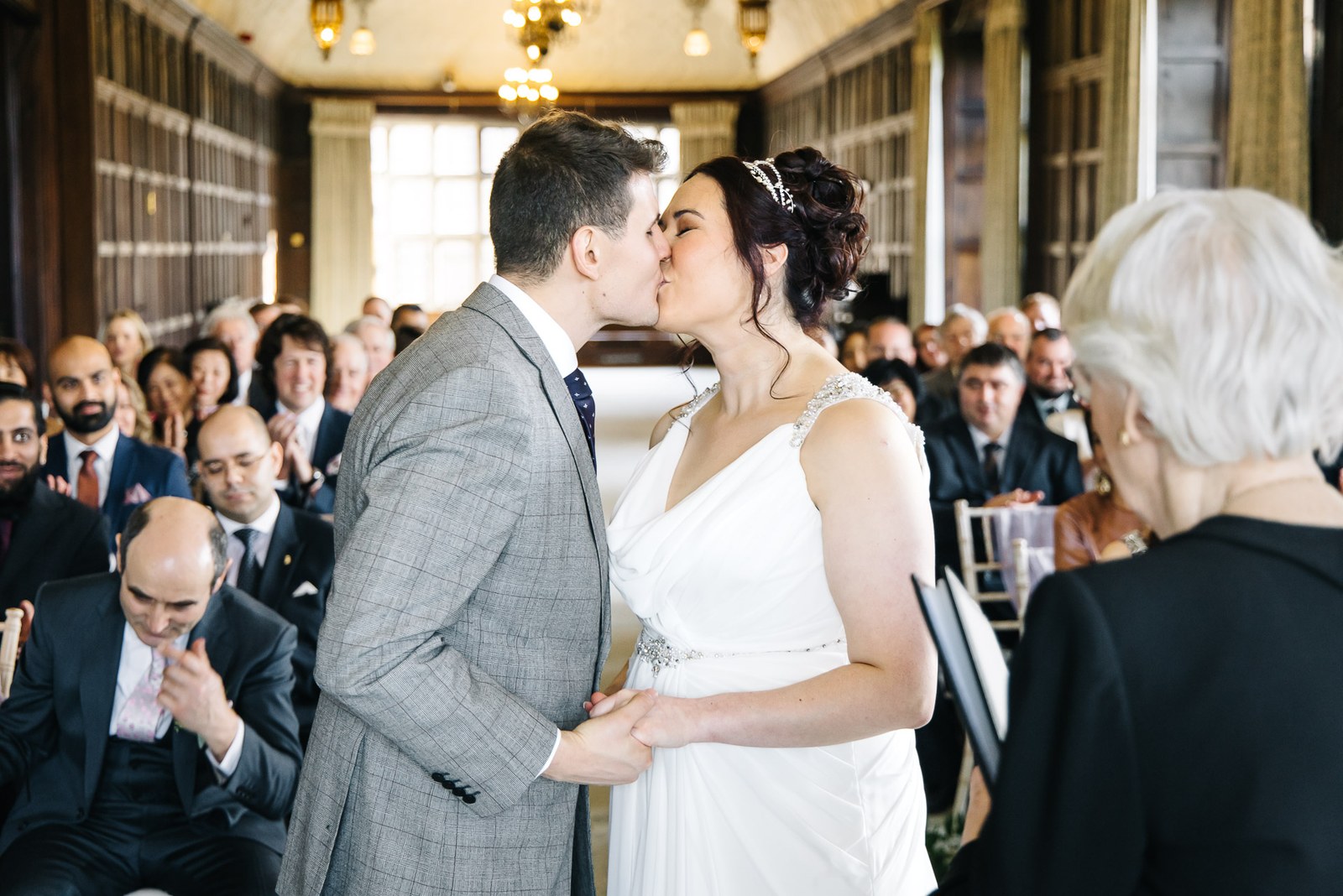The couple's first kiss as guests look on in the panelled gallery