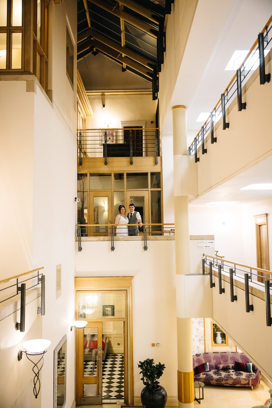 The couple on a mezzanine balcony overlooking the atrium at Fanhams Hall