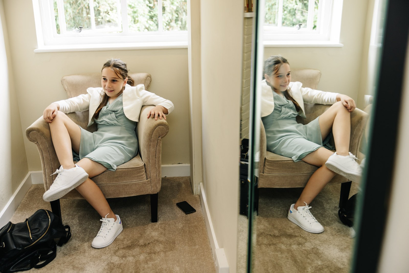 A flower girl in mint green relaxing in an armchair beside a mirror