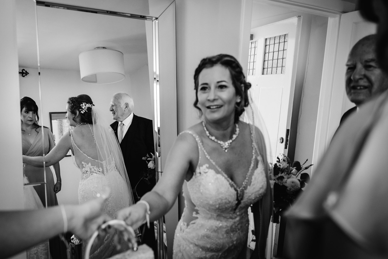 Black-and-white of the bride reaching out to take her bouquet before the ceremony