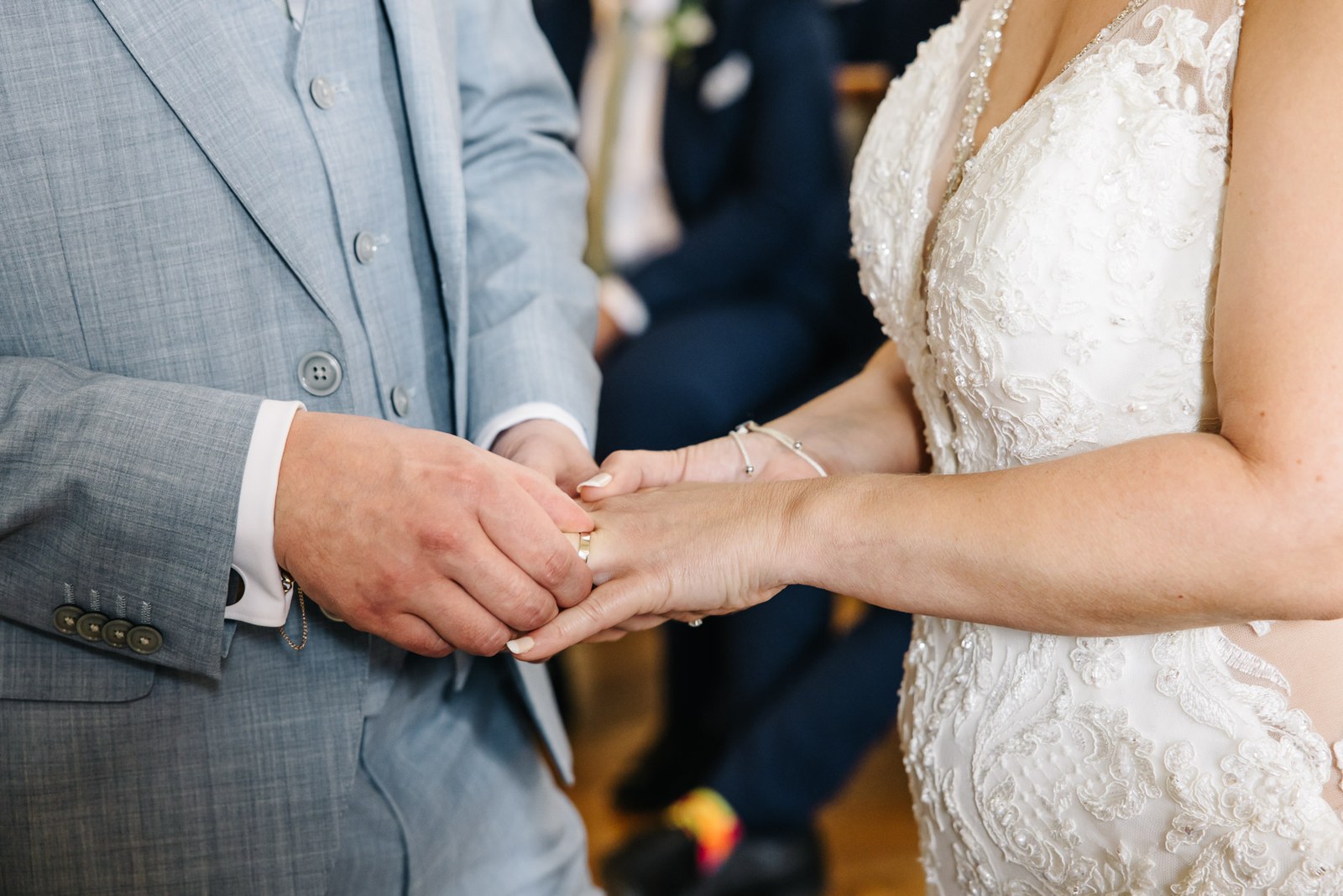 Close-up of the groom holding the bride's hands during the ceremony