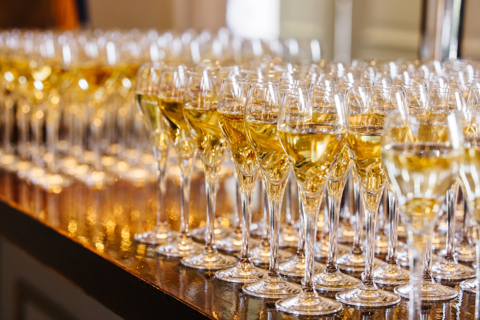 Rows of filled champagne flutes lined up along the bar