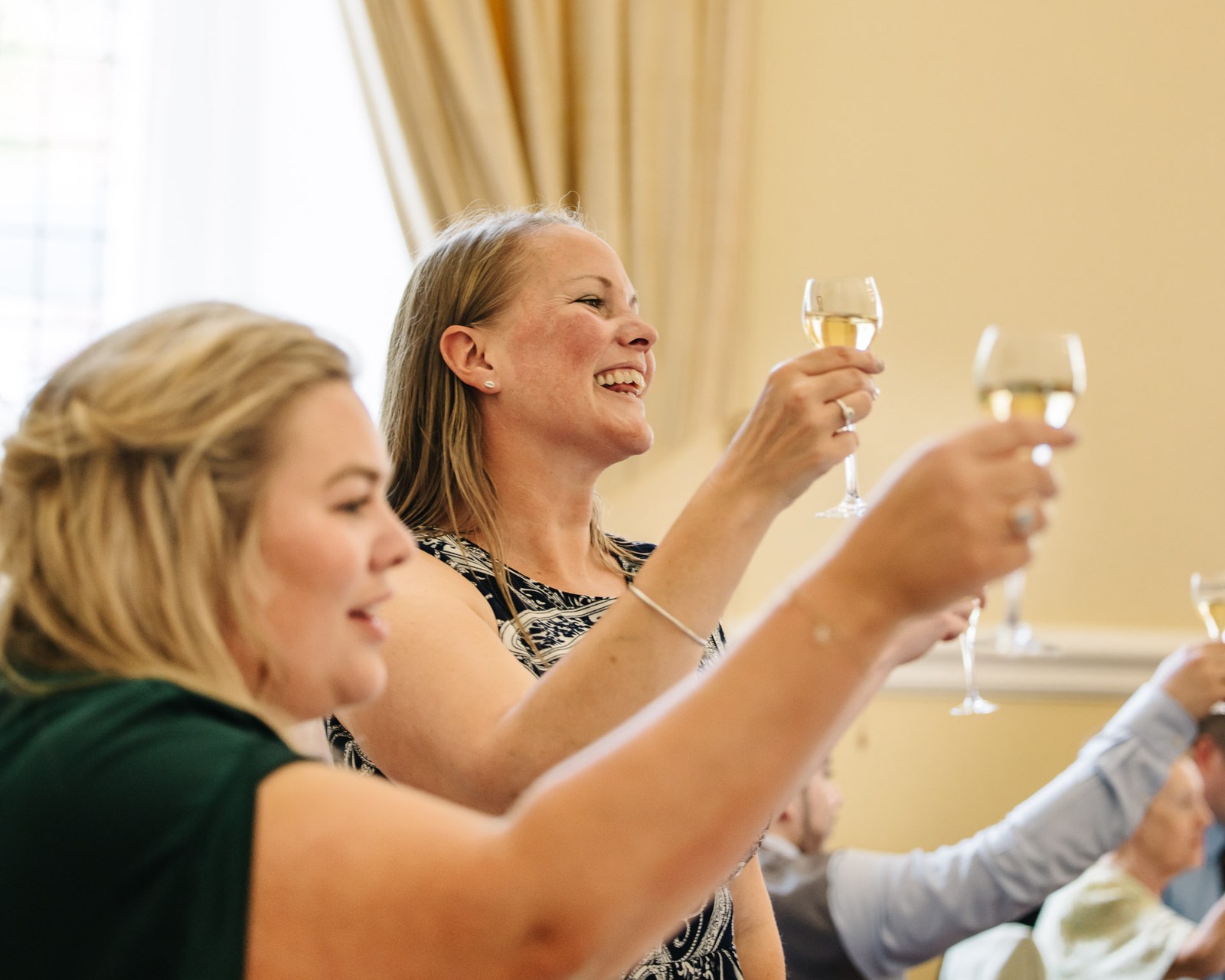 Guests laughing and raising their glasses for a toast