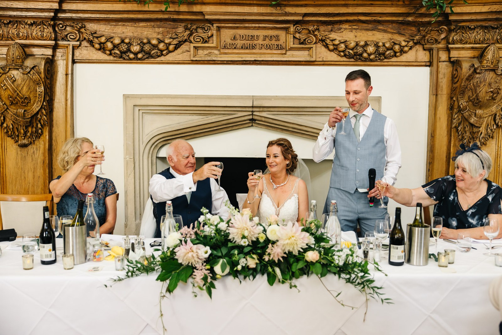 The groom rising to give his speech before the carved fireplace at Farnham Castle