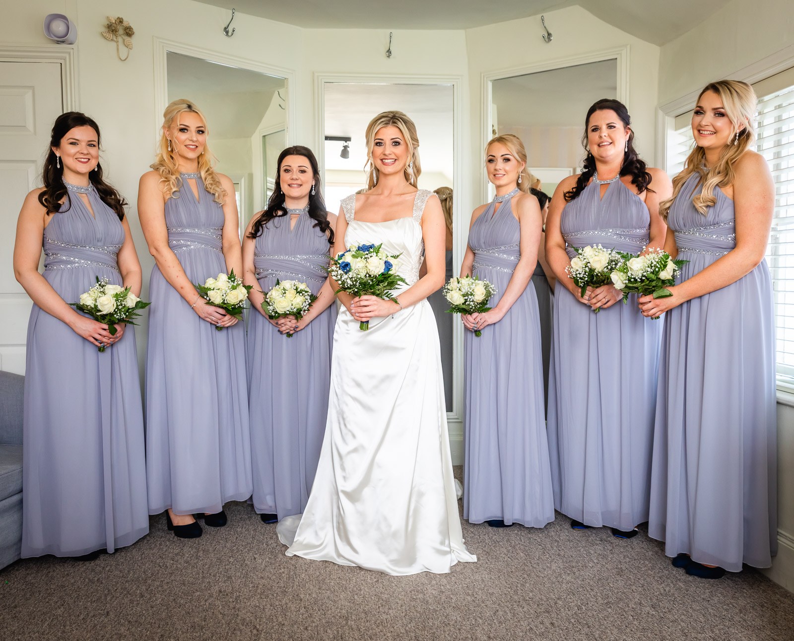 The bride with her lilac-clad bridesmaids, all holding bouquets