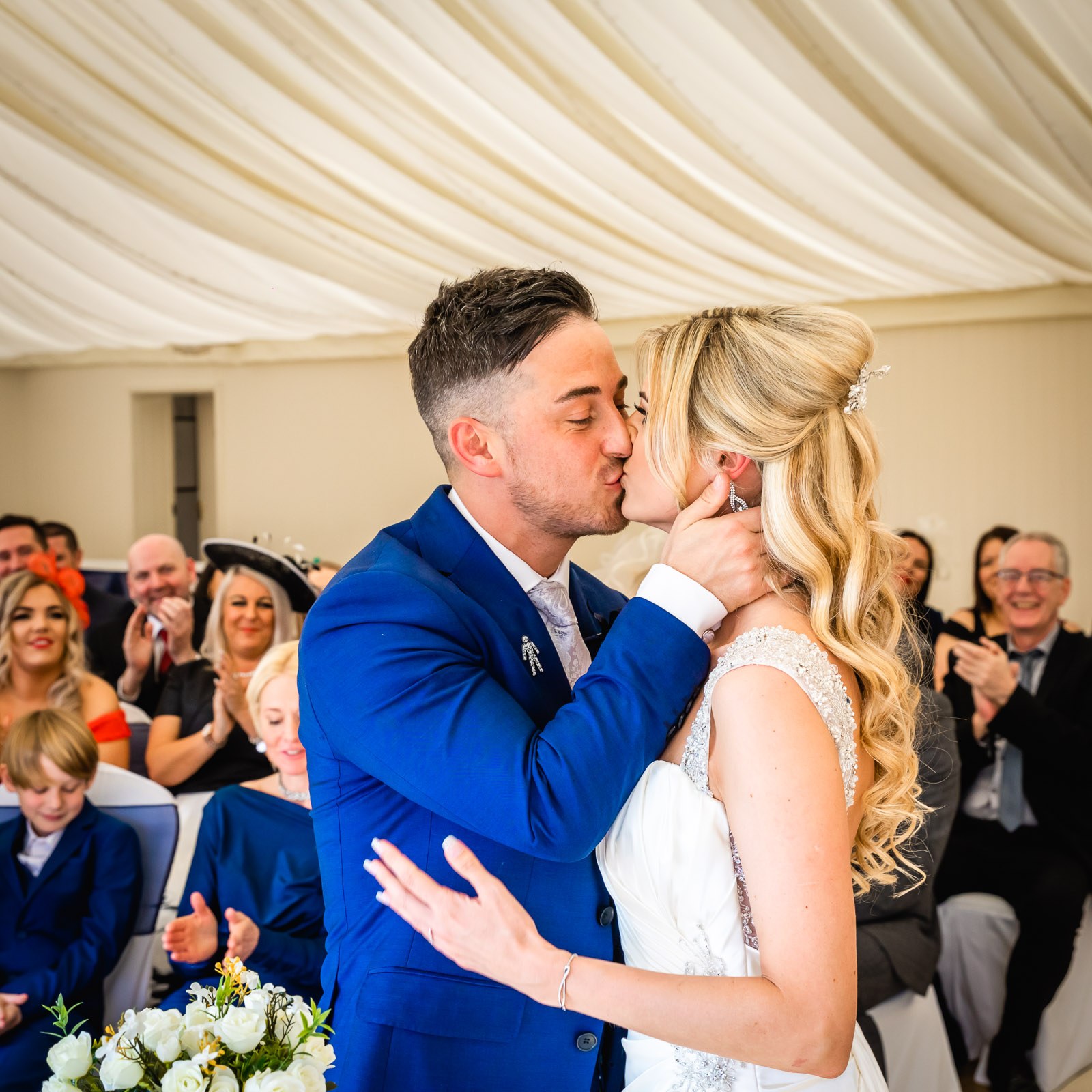 The couple's first kiss during the ceremony as guests applaud