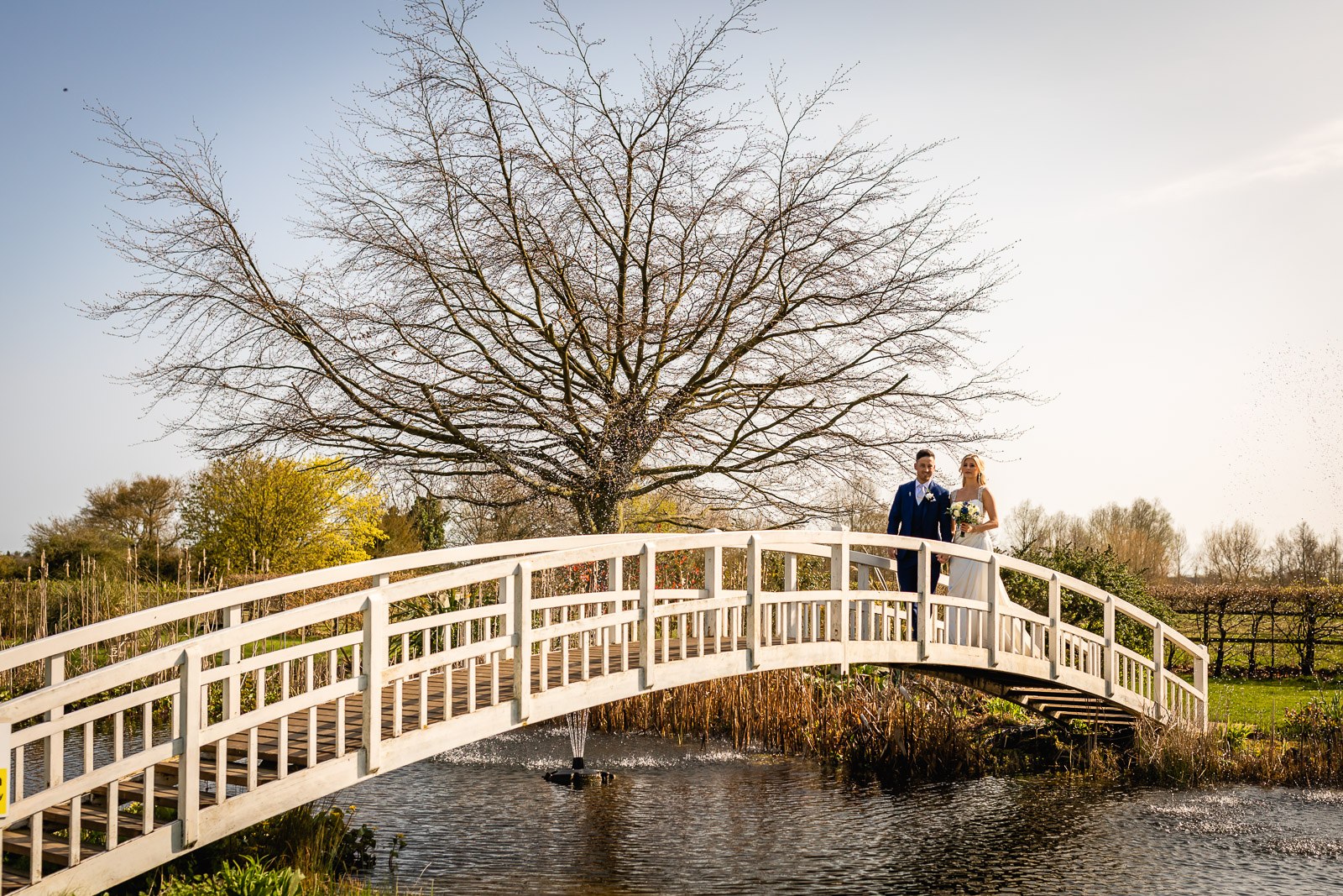 The couple on the white ornamental footbridge over the lake at Fennes