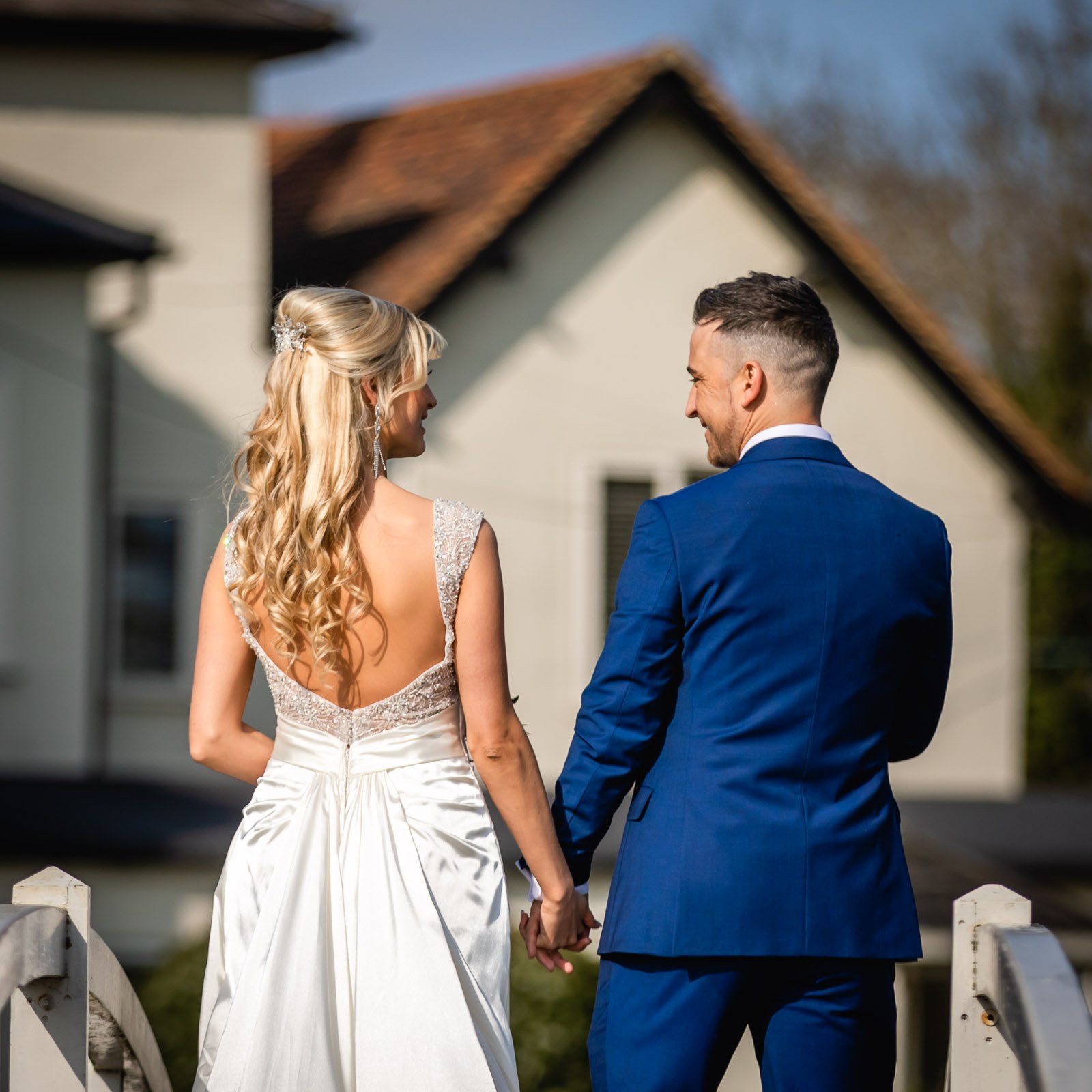 The couple facing each other on the bridge, the country house behind