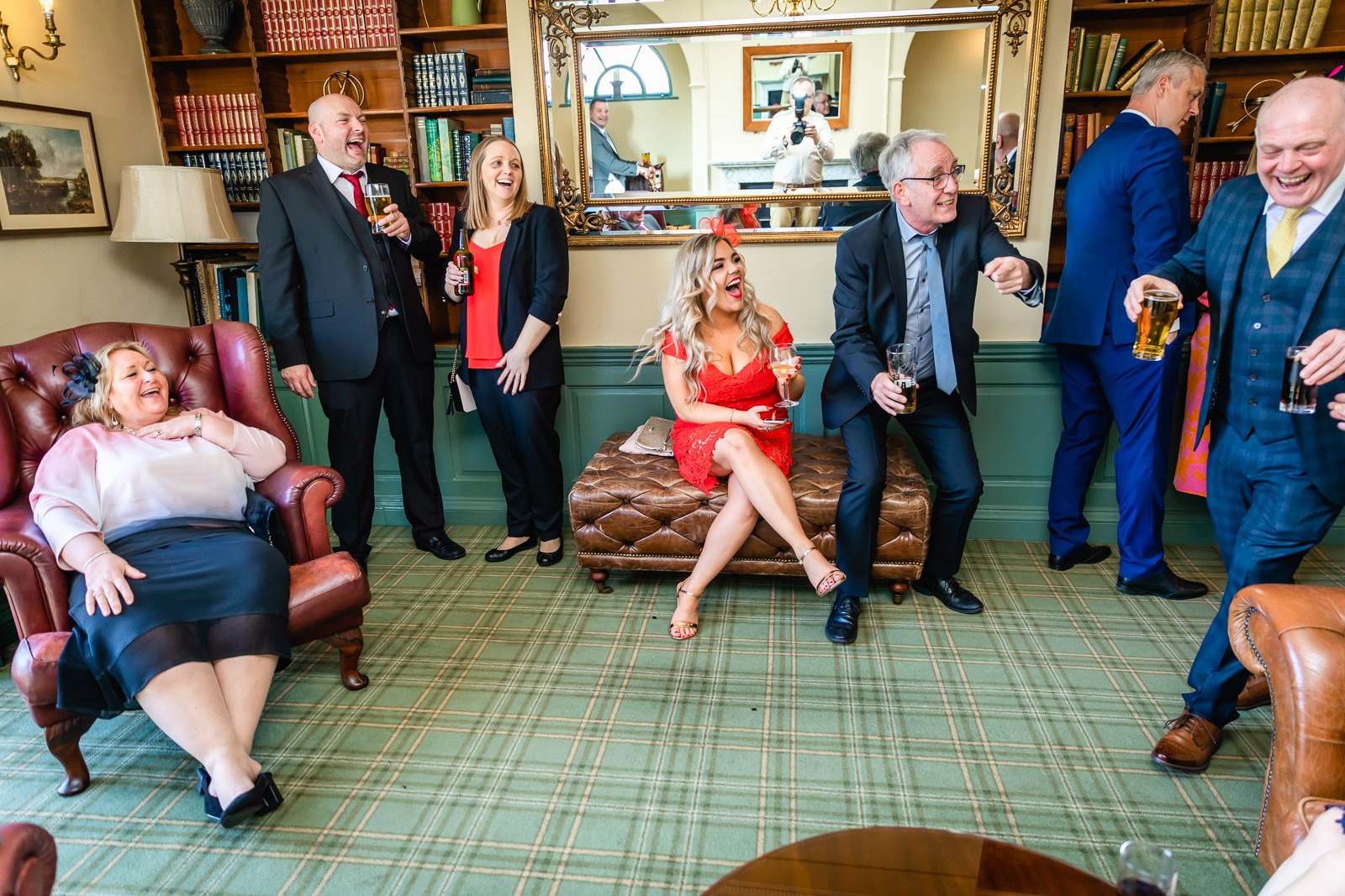 Guests relaxing among leather Chesterfields in the library lounge at Fennes