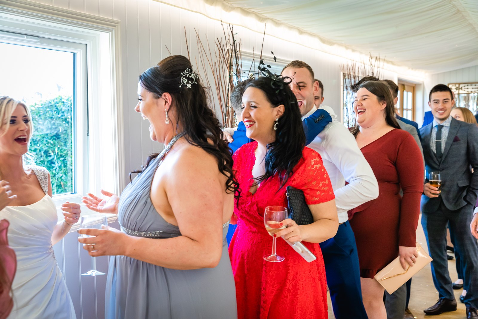 Guests chatting and laughing over drinks in the light-filled room