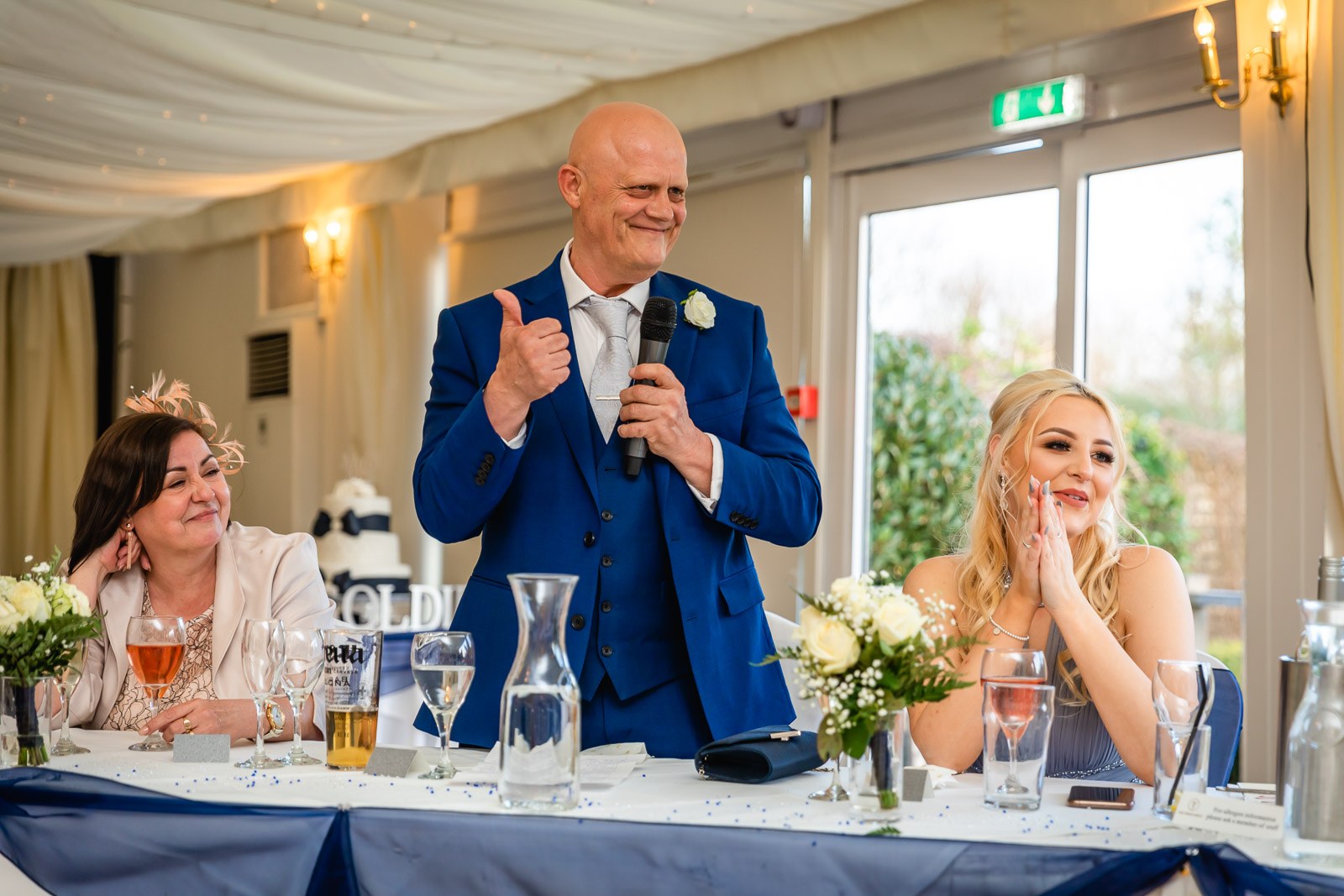 The father of the bride giving a thumbs-up during his speech