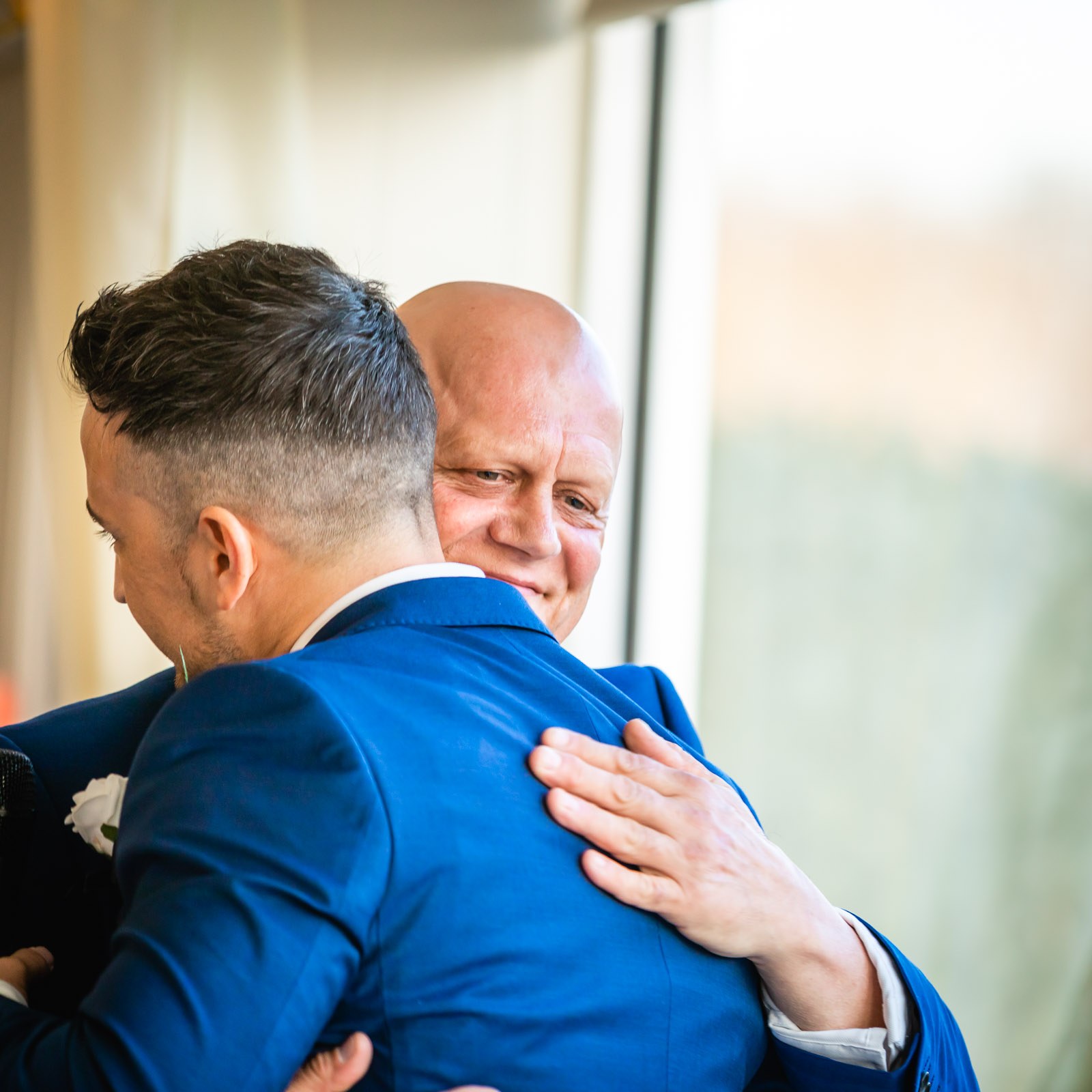 The groom embracing the father of the bride during the speeches