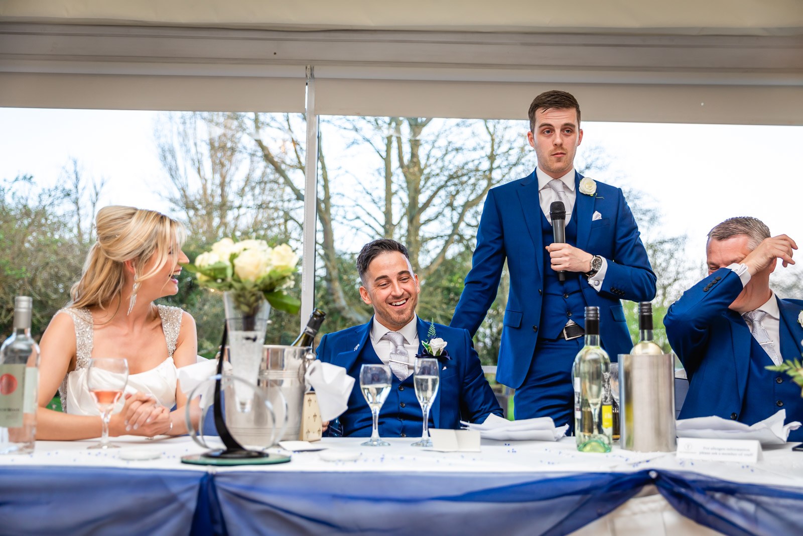 The best man giving his speech to the seated top table
