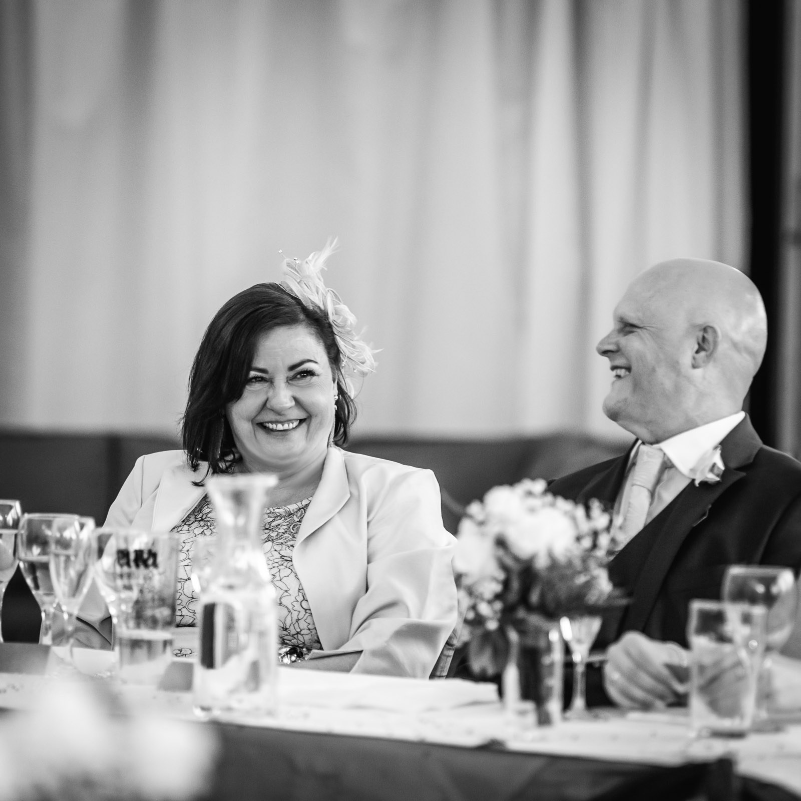 Black-and-white of two guests laughing together at the table