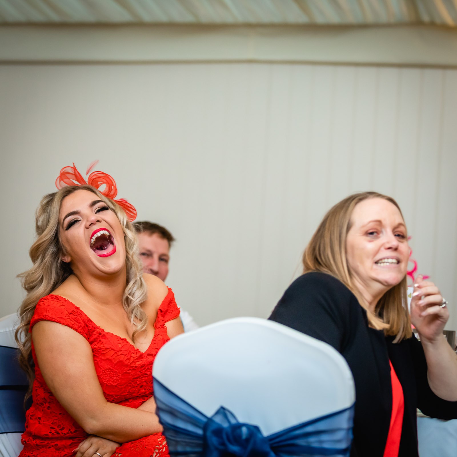 A guest in red laughing during the speeches
