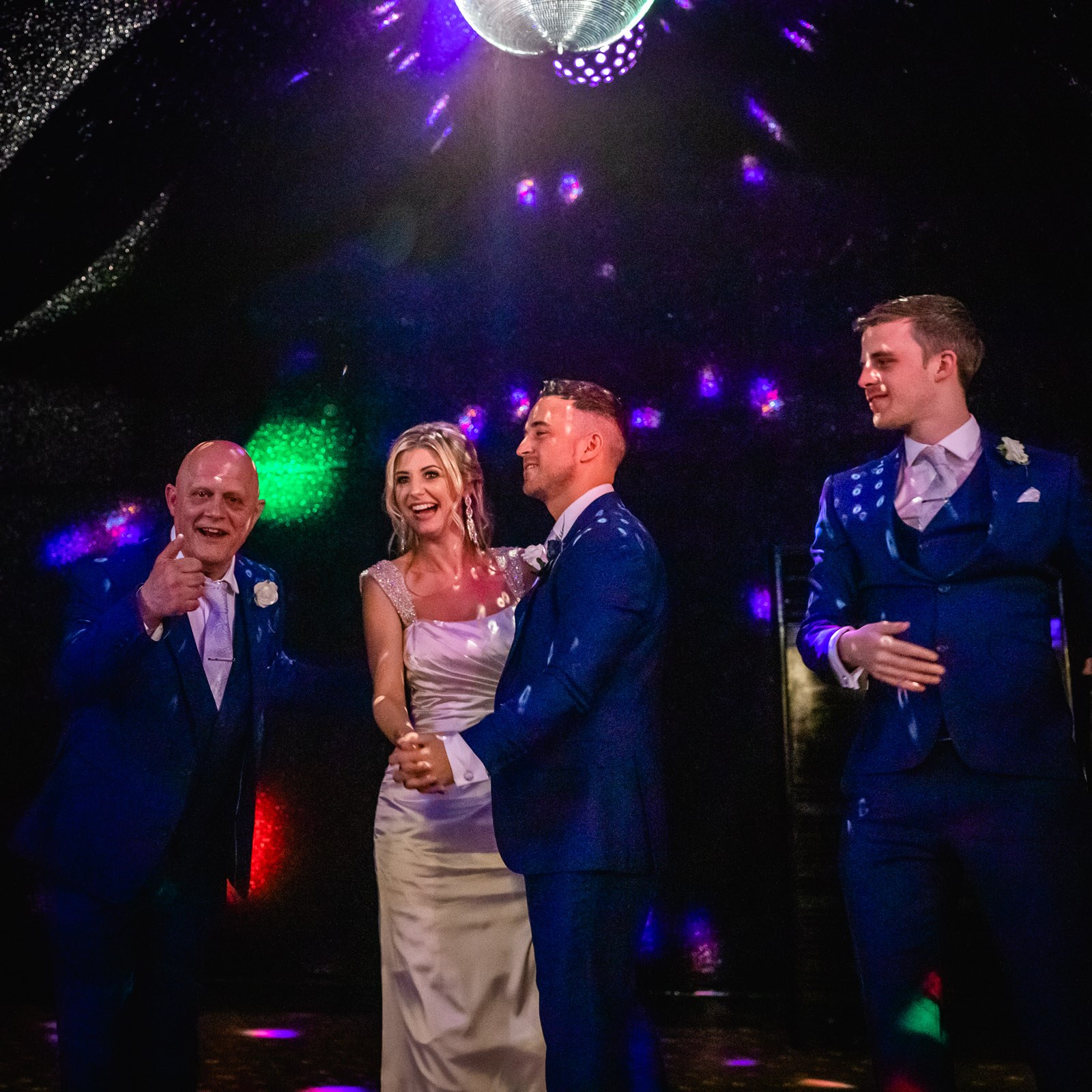 The couple dancing as family join in under the disco lights