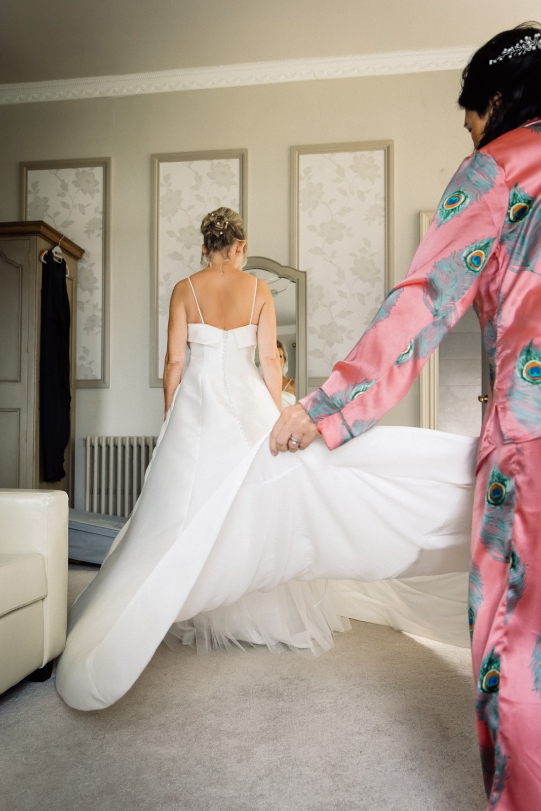 The back of the bride's satin gown as her train is carried out before the ceremony