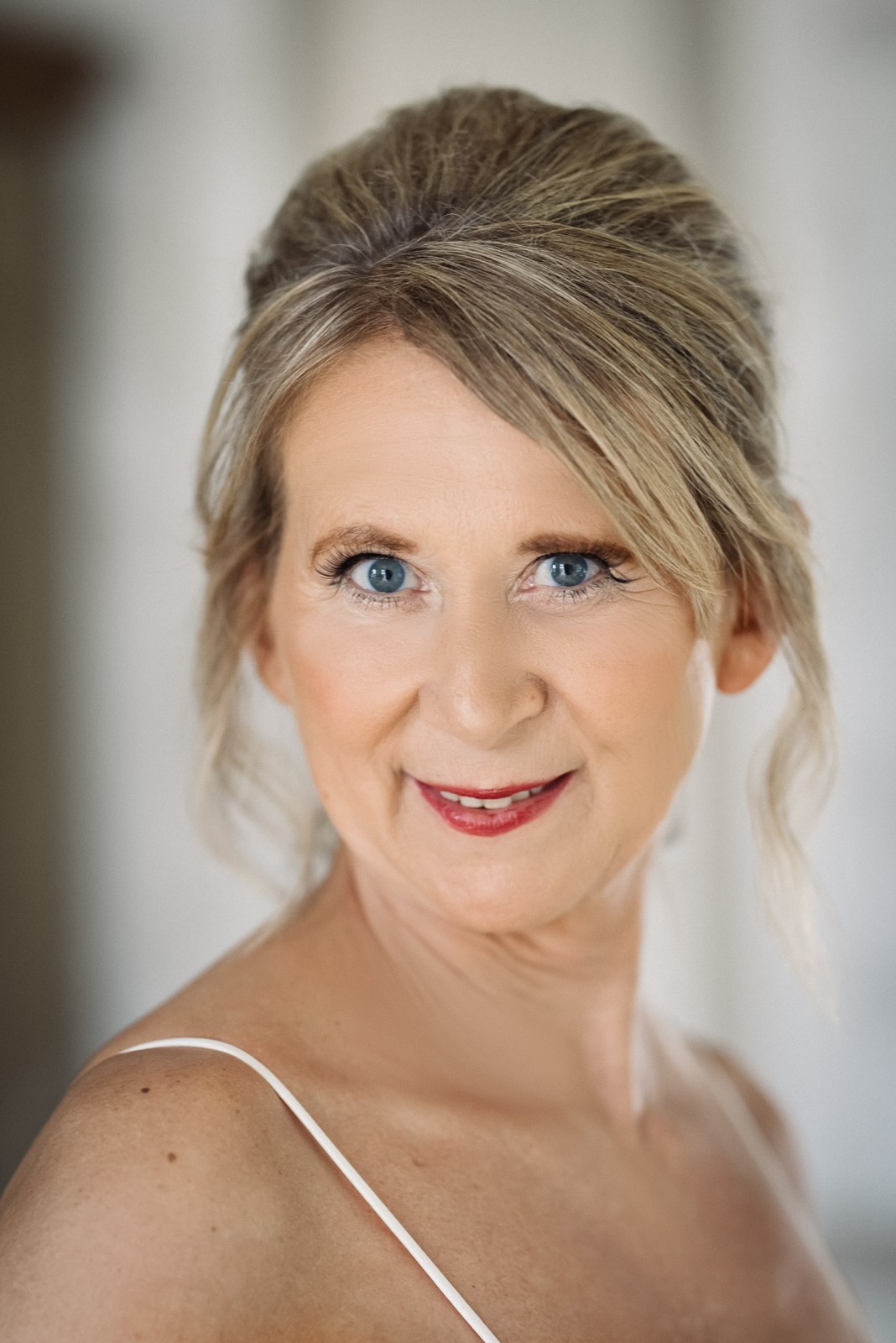 Close portrait of the bride with a soft updo and natural makeup
