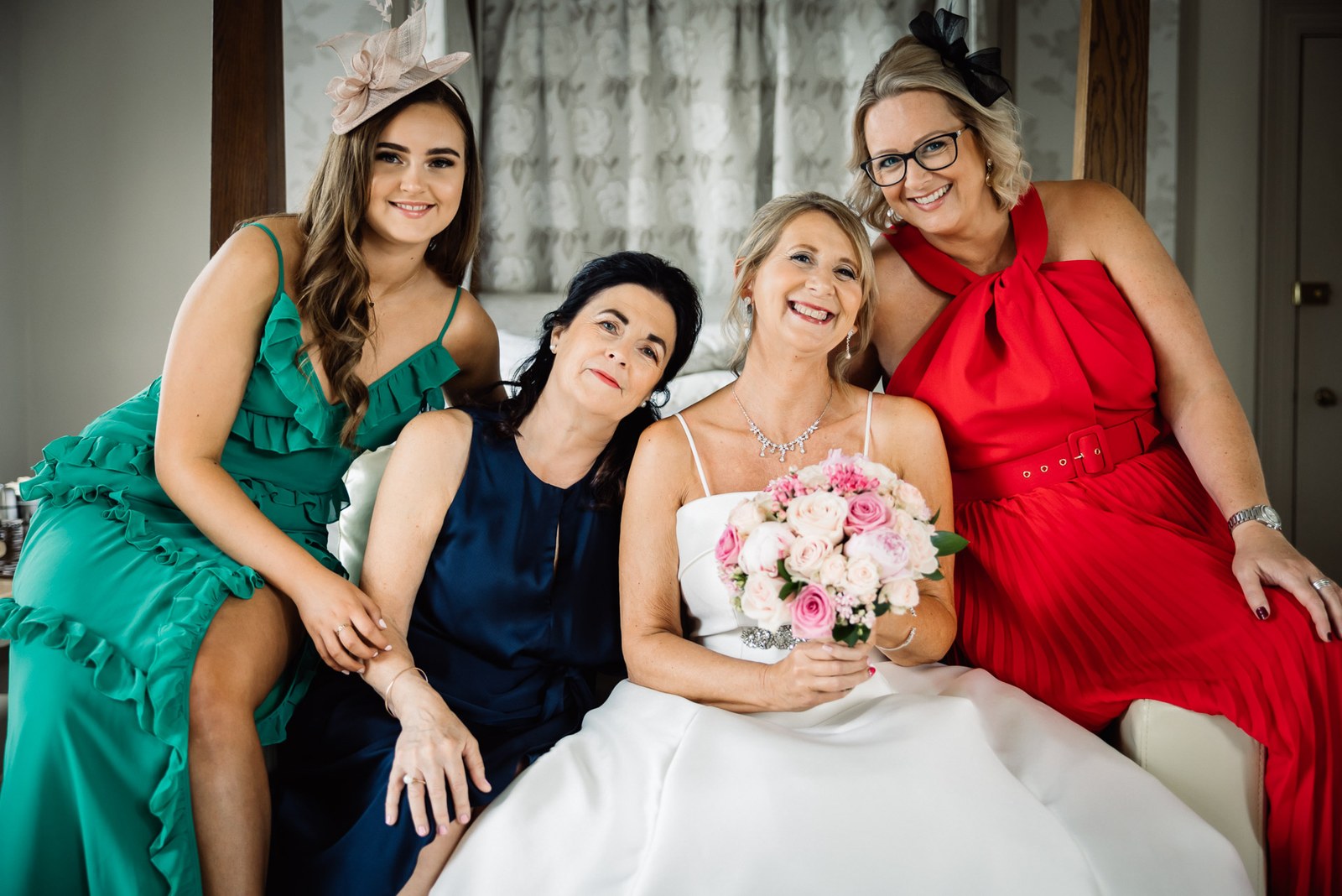 The bride seated with three guests in their colourful dresses before the ceremony