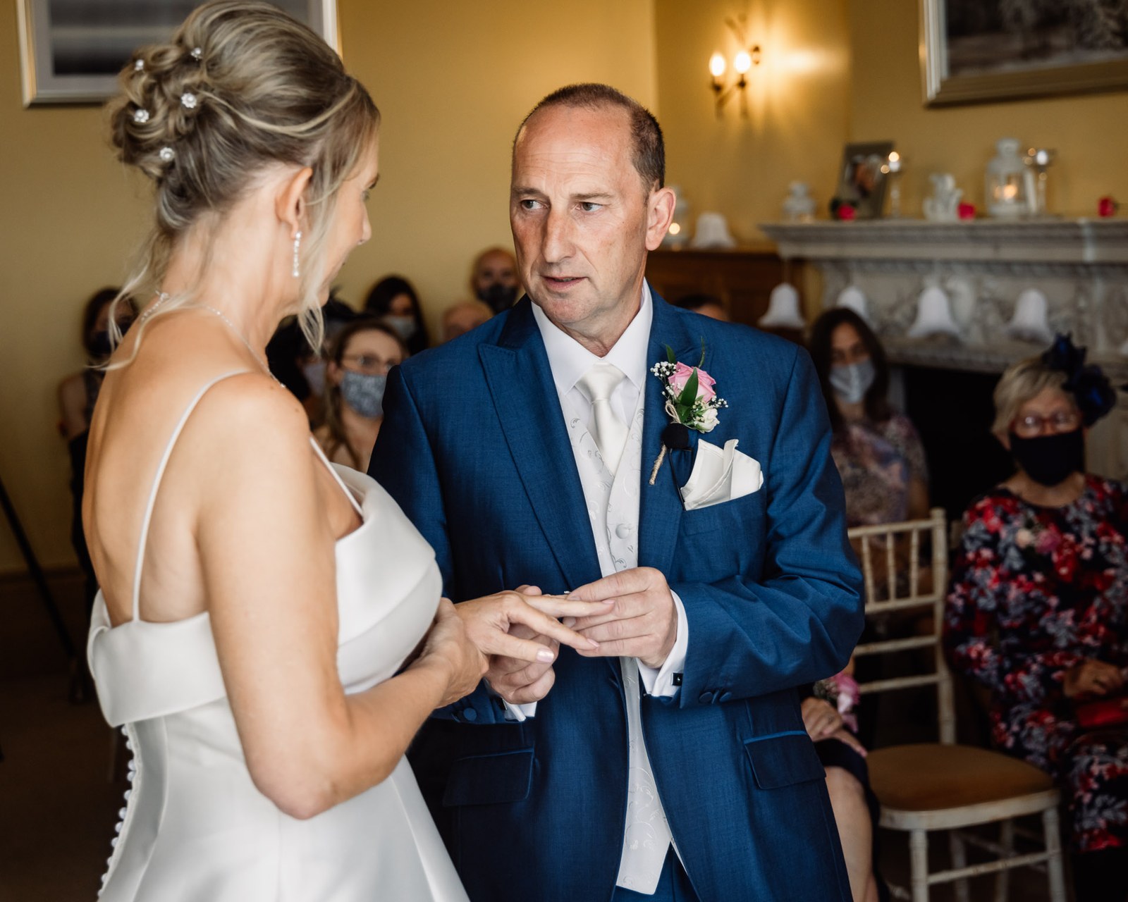 The groom placing the ring on the bride's finger during the ceremony