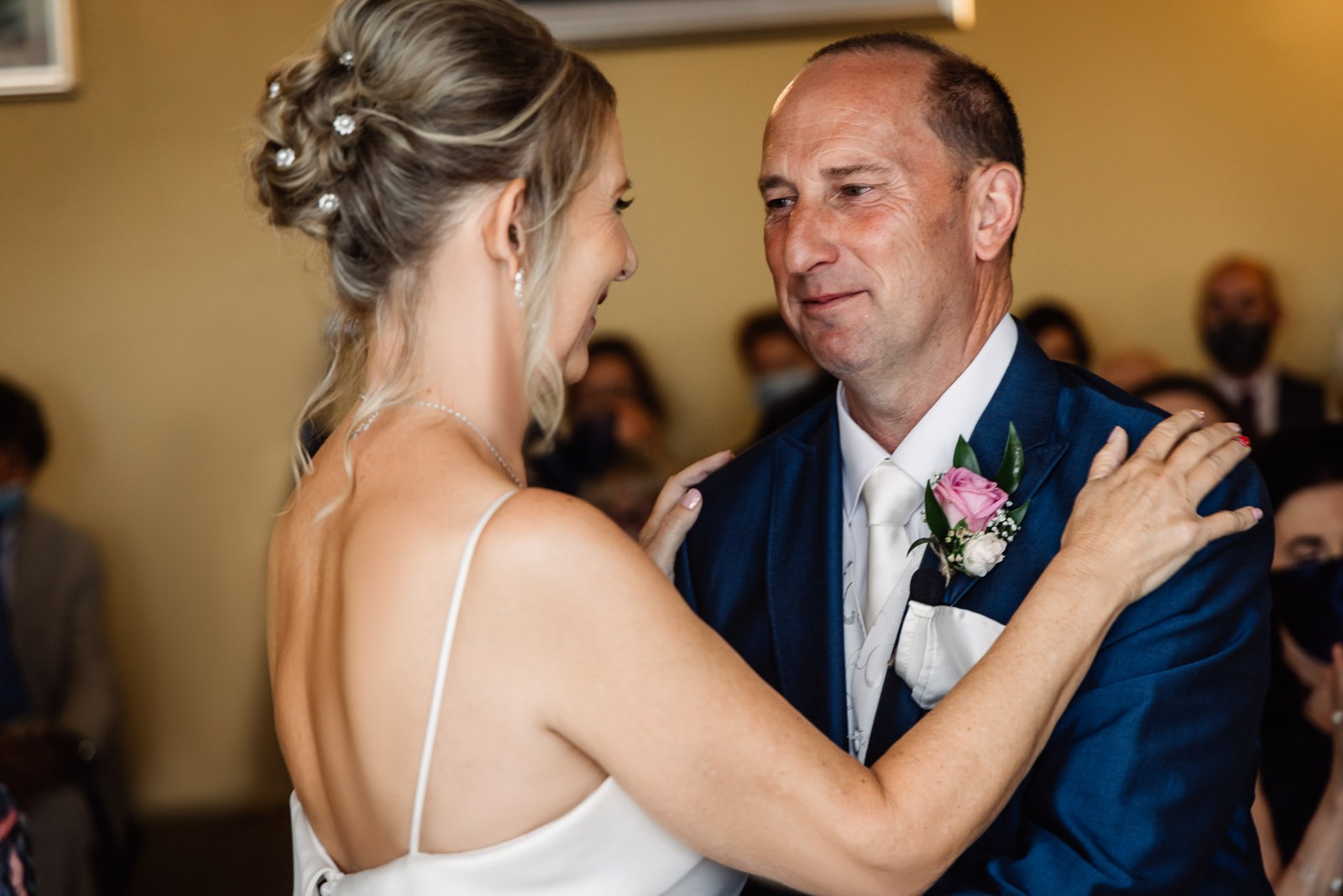Bride and groom embracing at the front of the ceremony room