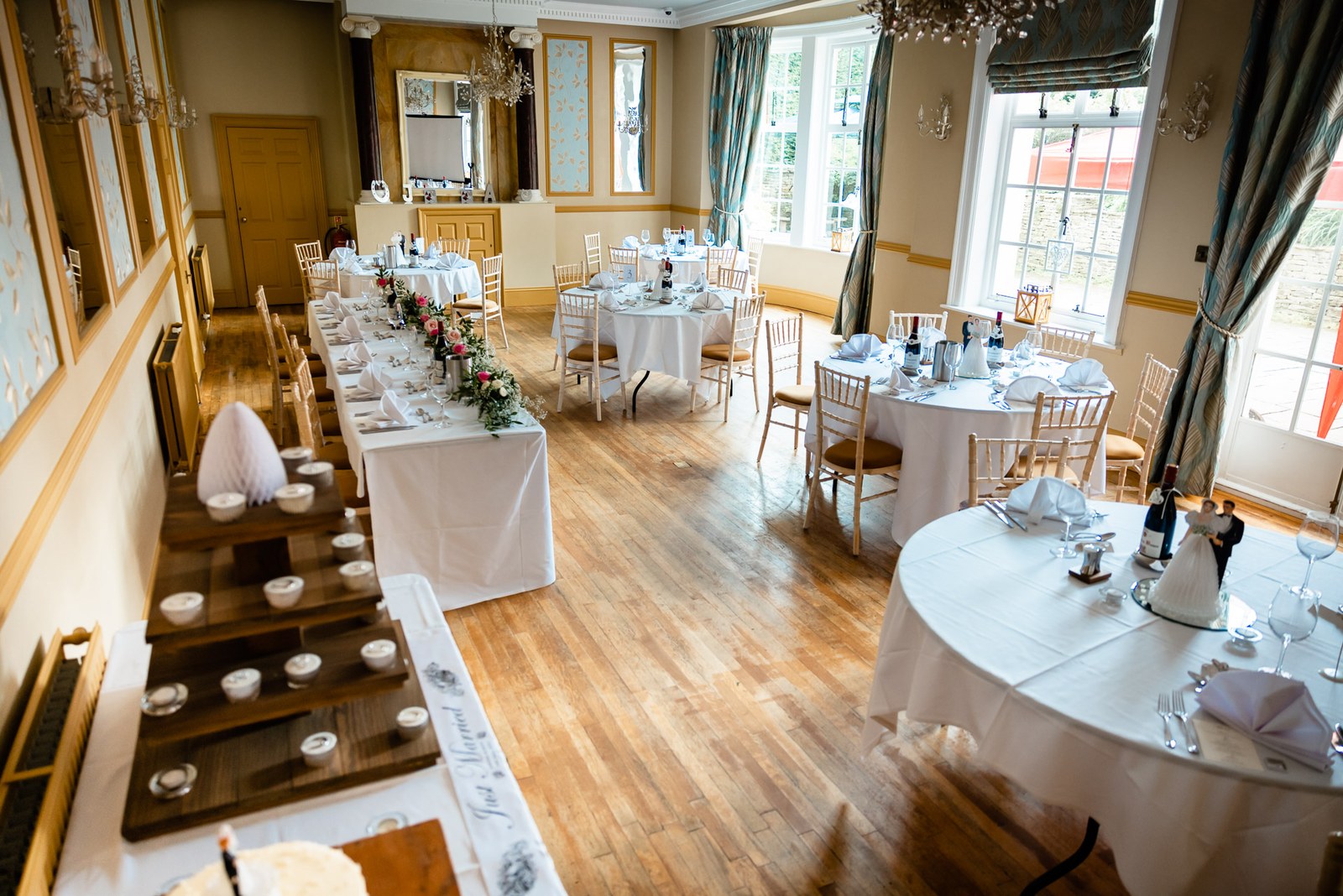 The wedding breakfast room at Glenfall House laid with round tables and a long top table