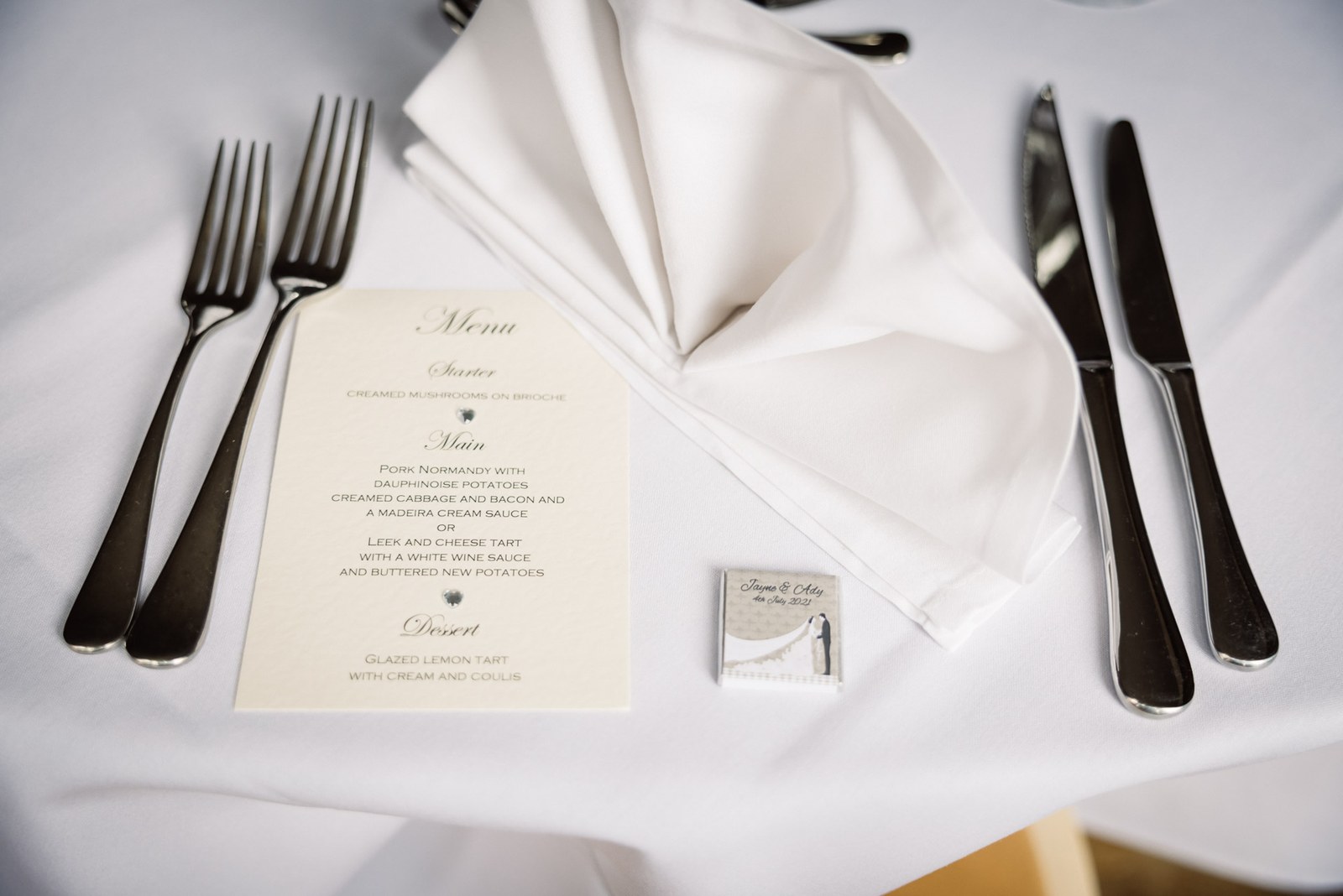 A place setting with printed menu, folded napkin and polished cutlery