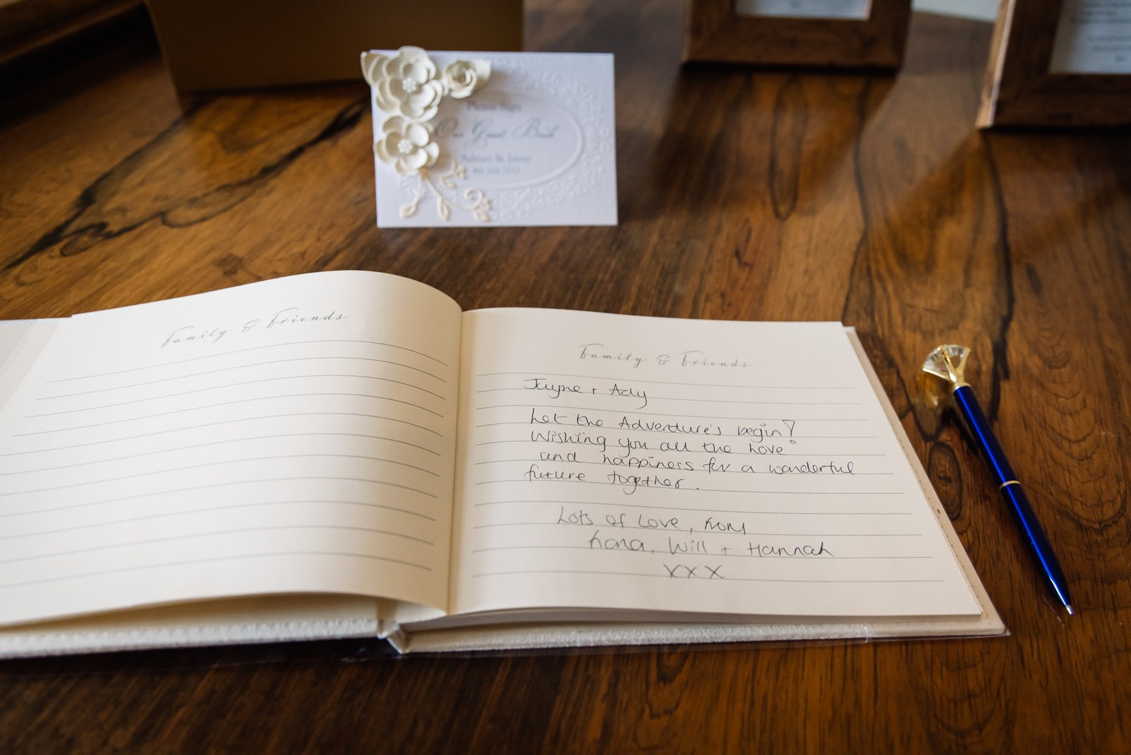 An open guest book with a handwritten message and a blue pen