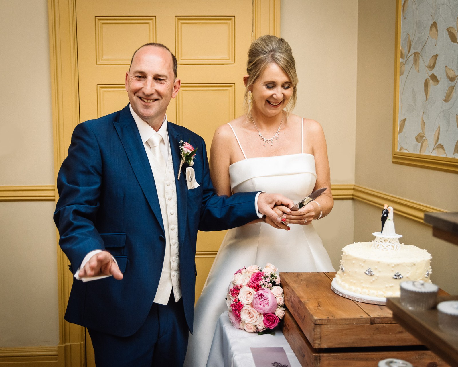 Bride and groom cutting their wedding cake together