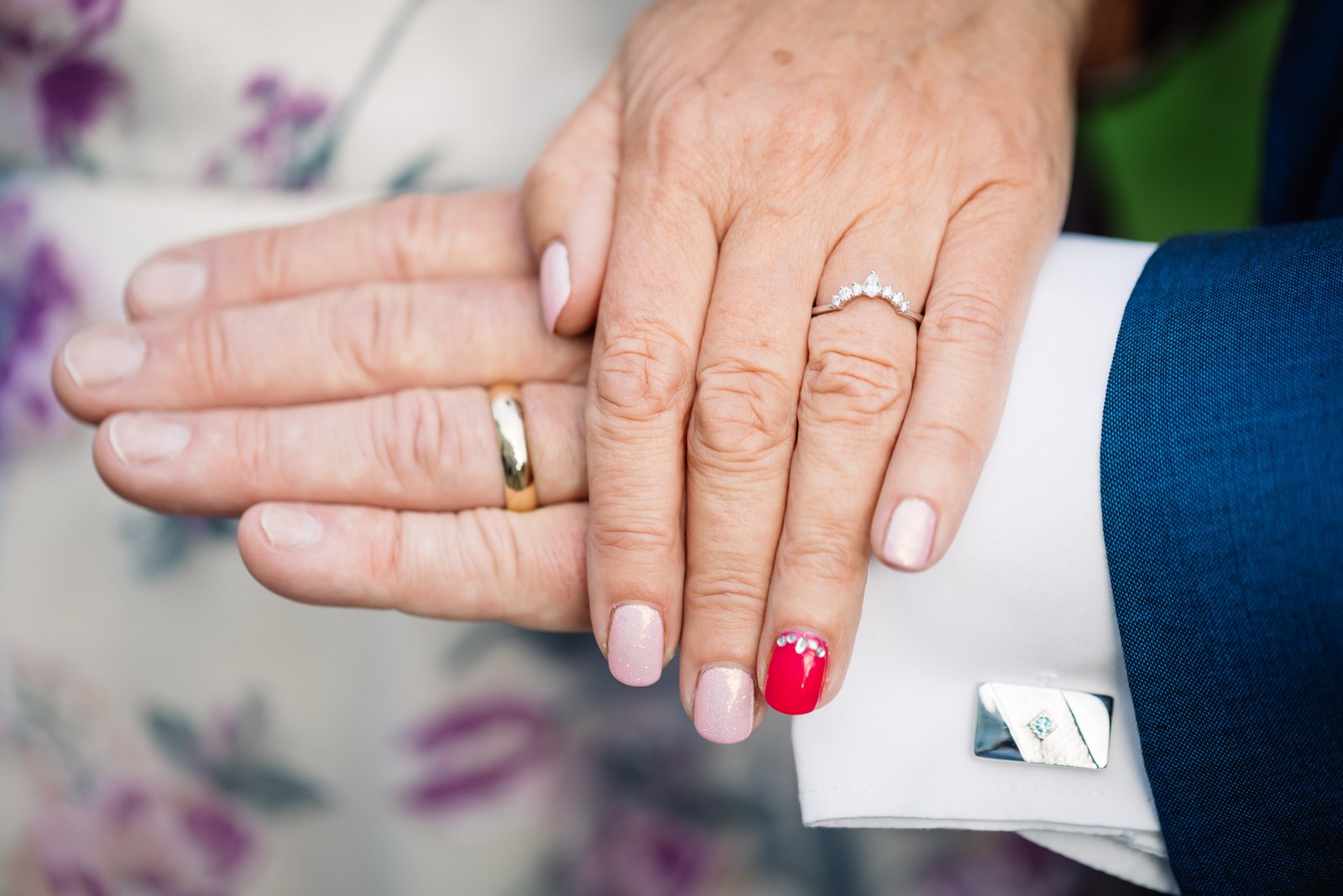 Close-up of the couple's hands showing their new wedding rings