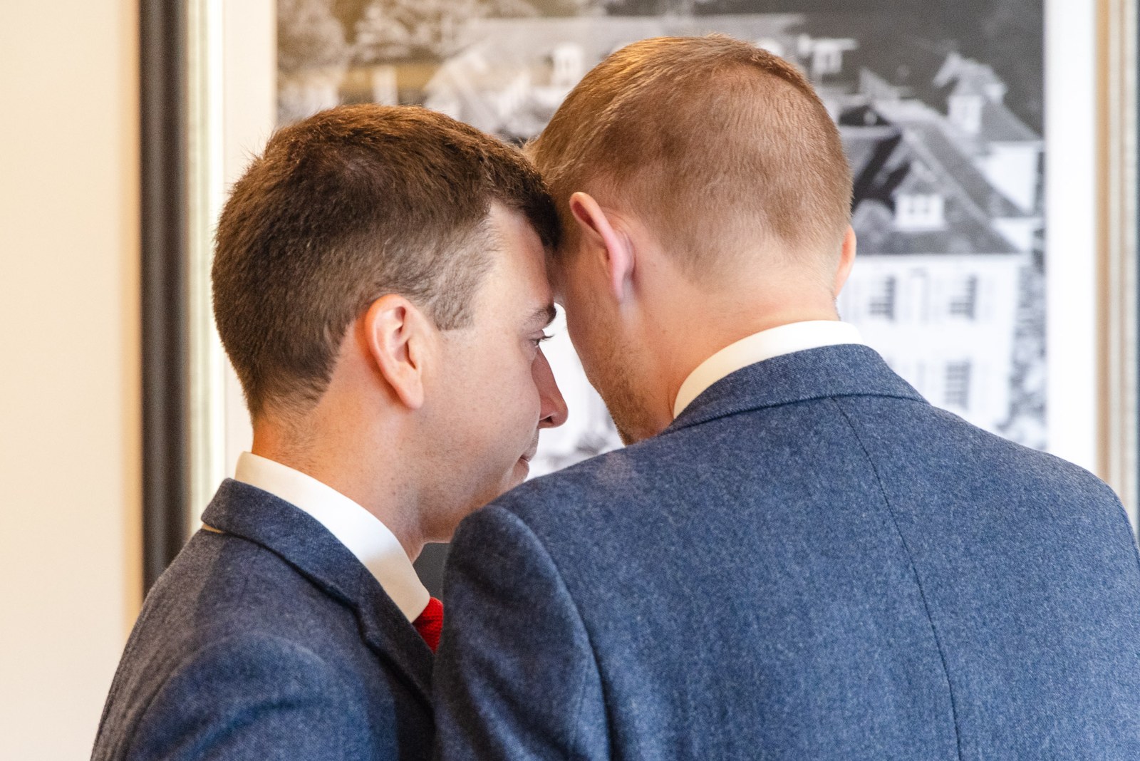 The grooms close together, foreheads almost touching, before the day begins
