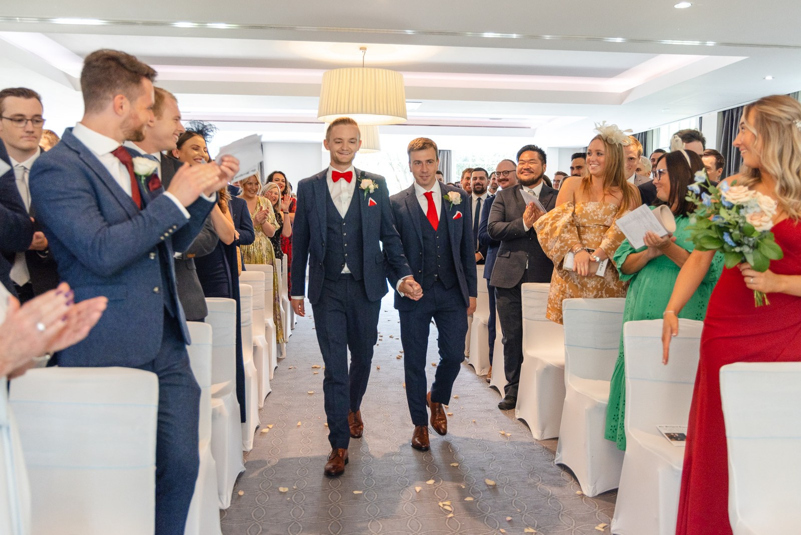 The newlyweds walking back down the aisle as guests applaud