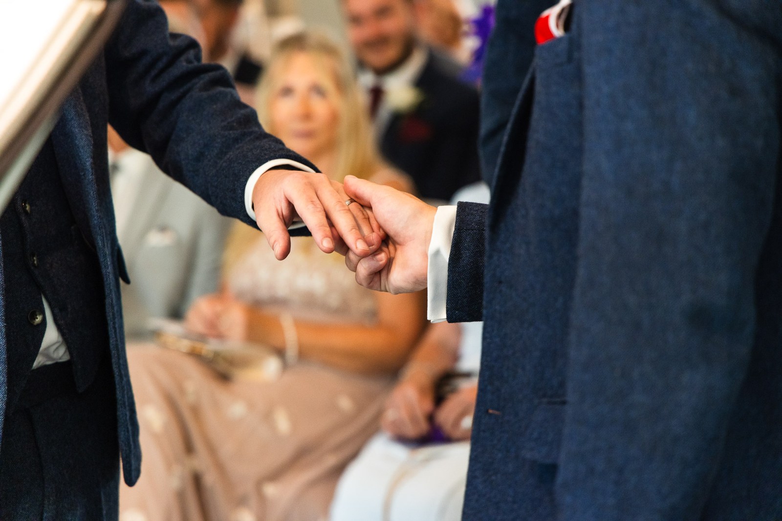 Close-up of a wedding ring being slipped onto a finger during the ceremony