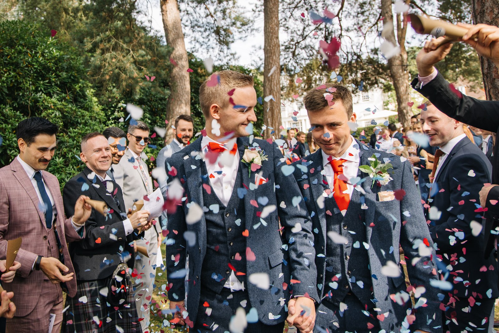The newlyweds walk through a shower of confetti in the grounds