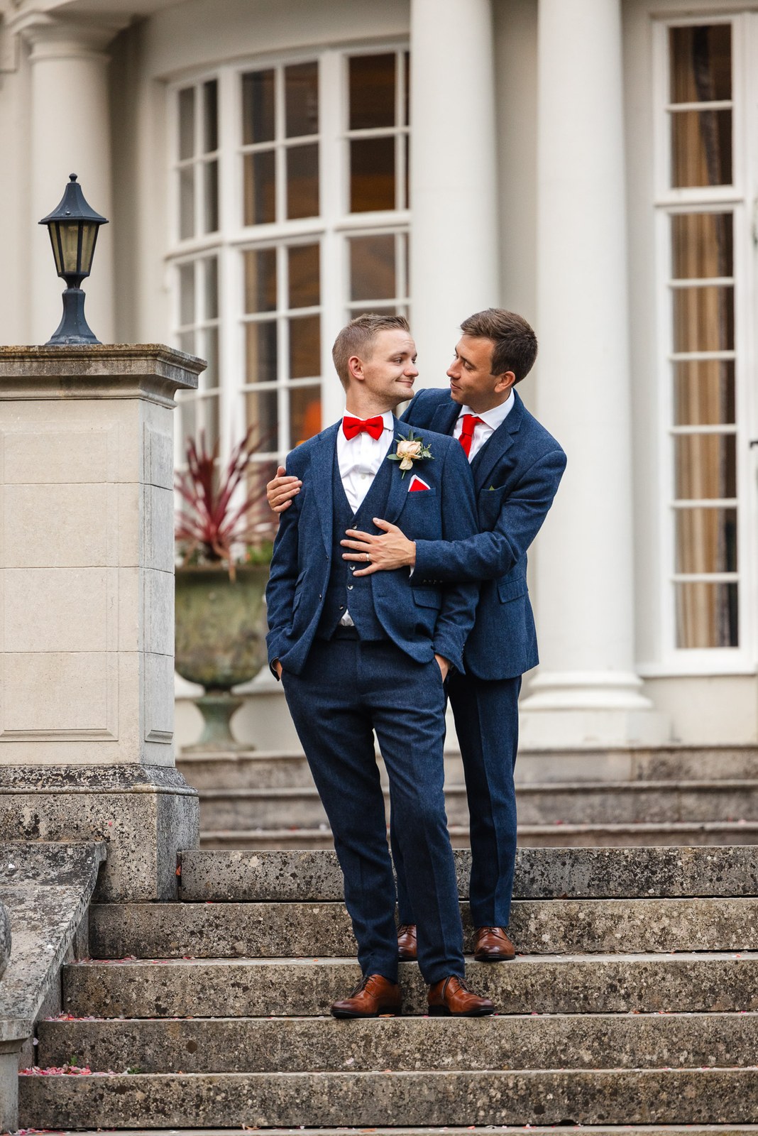 The two grooms embracing on the stone entrance steps of Gorse Hill Hotel