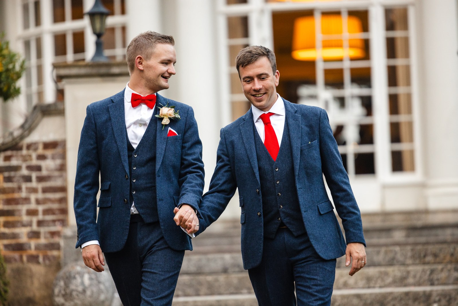 The newlyweds walking hand in hand past the white frontage of Gorse Hill Hotel