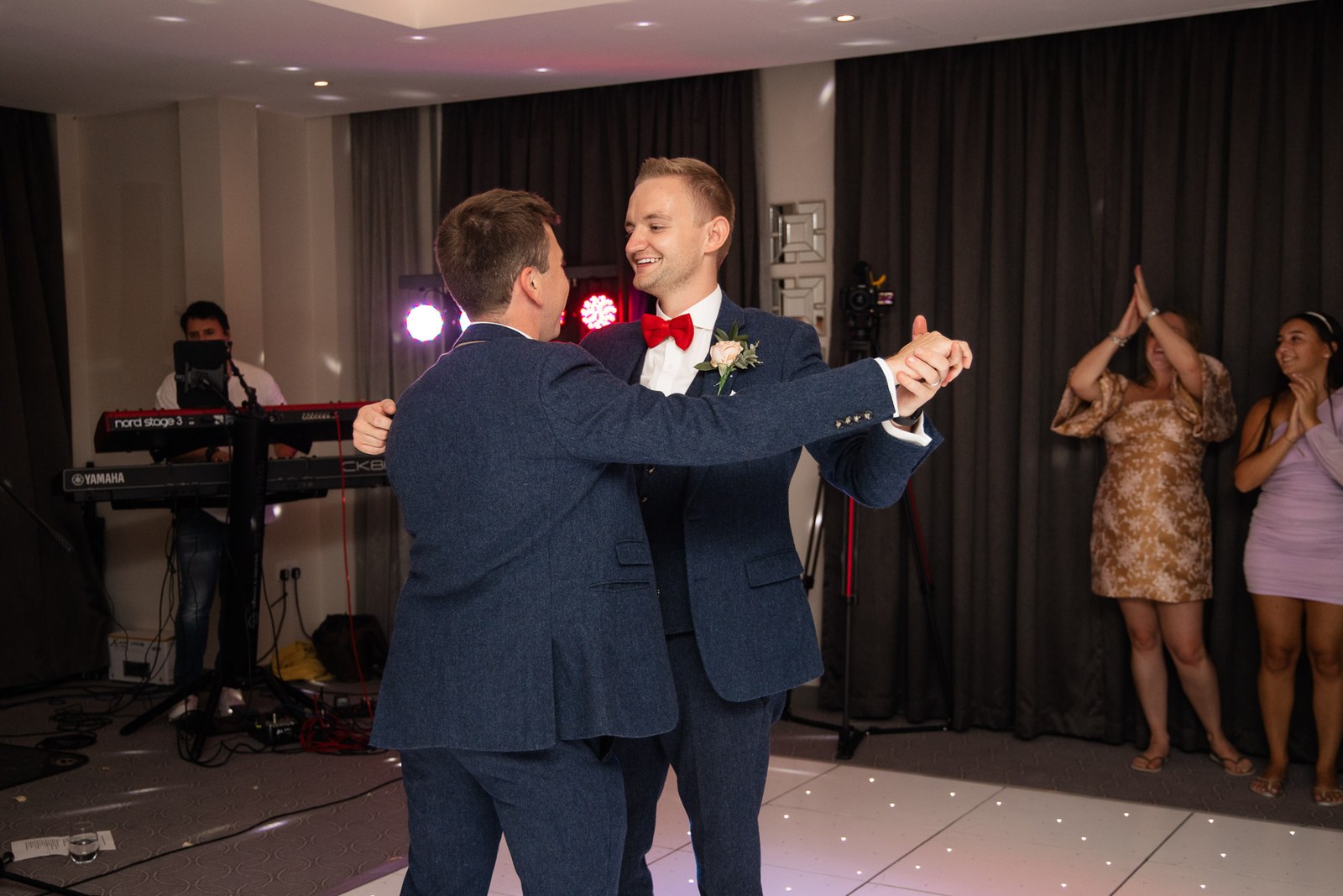 The two grooms sharing their first dance as the band plays behind them