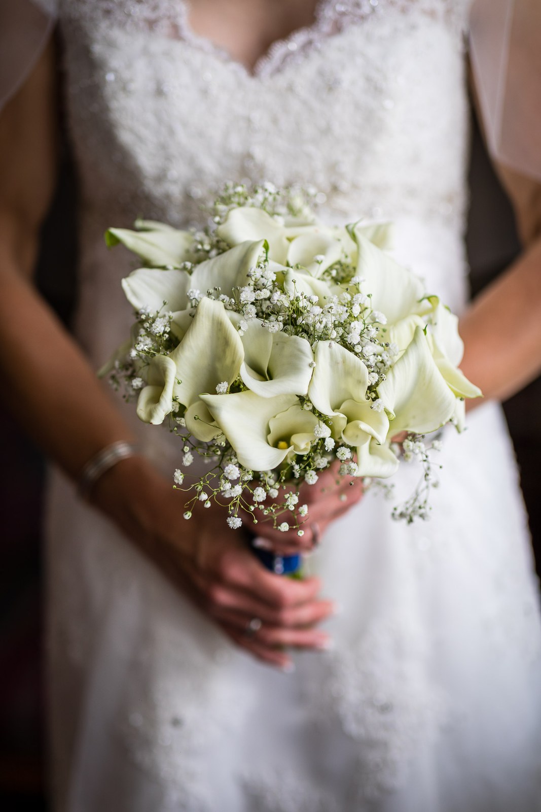 Close-up of the bride holding her calla lily and gypsophila bouquet