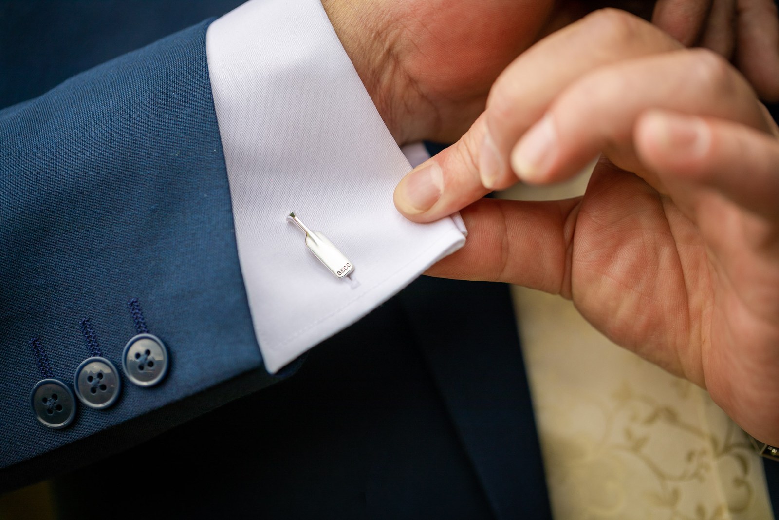 Close-up of the groom fastening a cufflink