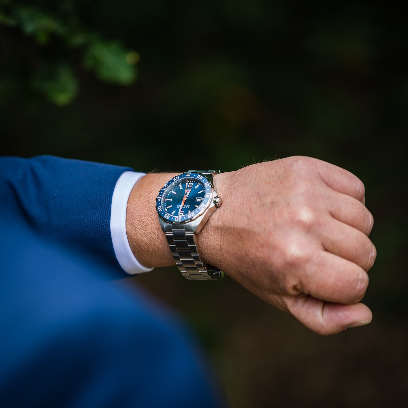 Close-up of the groom's blue-dial wristwatch