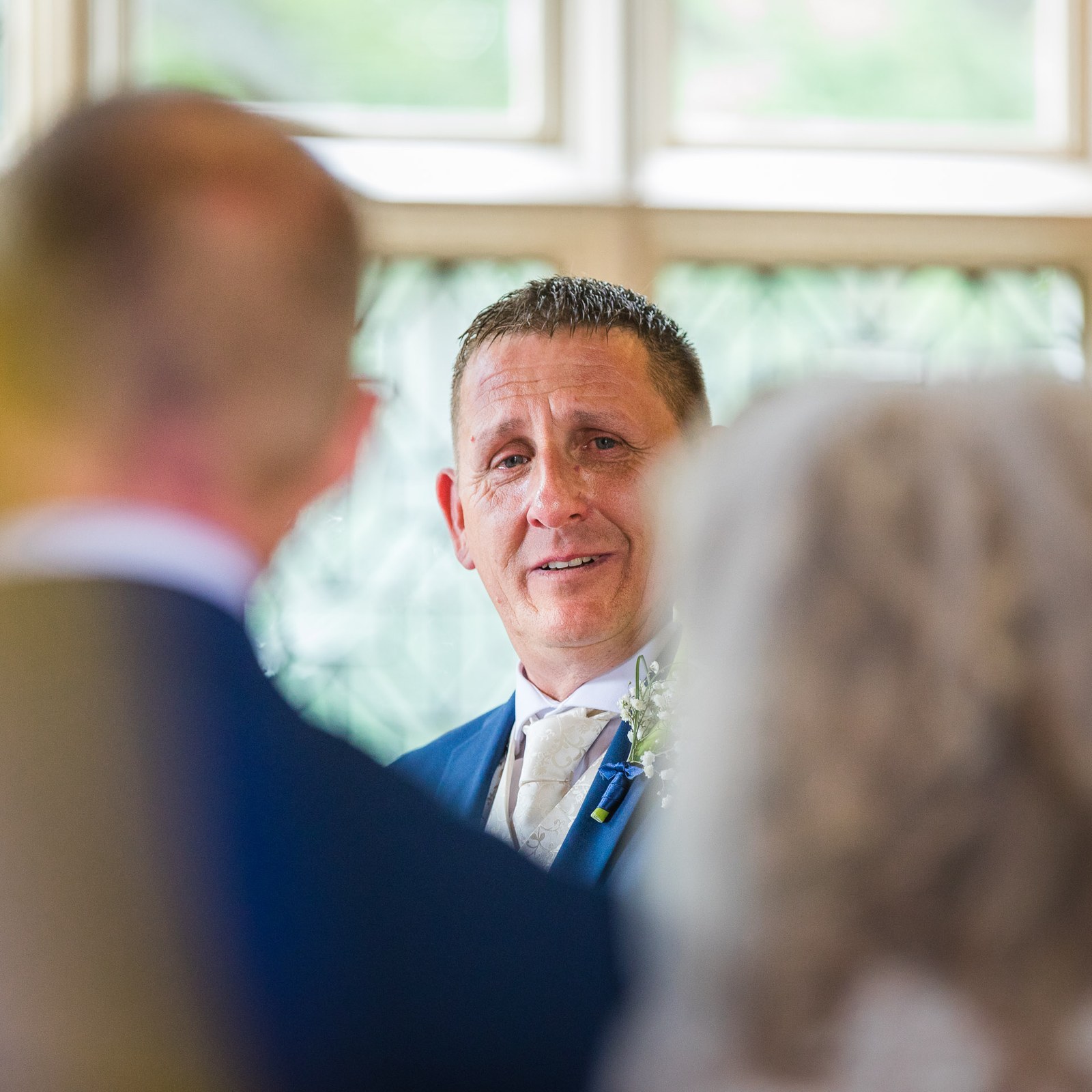 The groom looking emotional as his bride approaches down the aisle