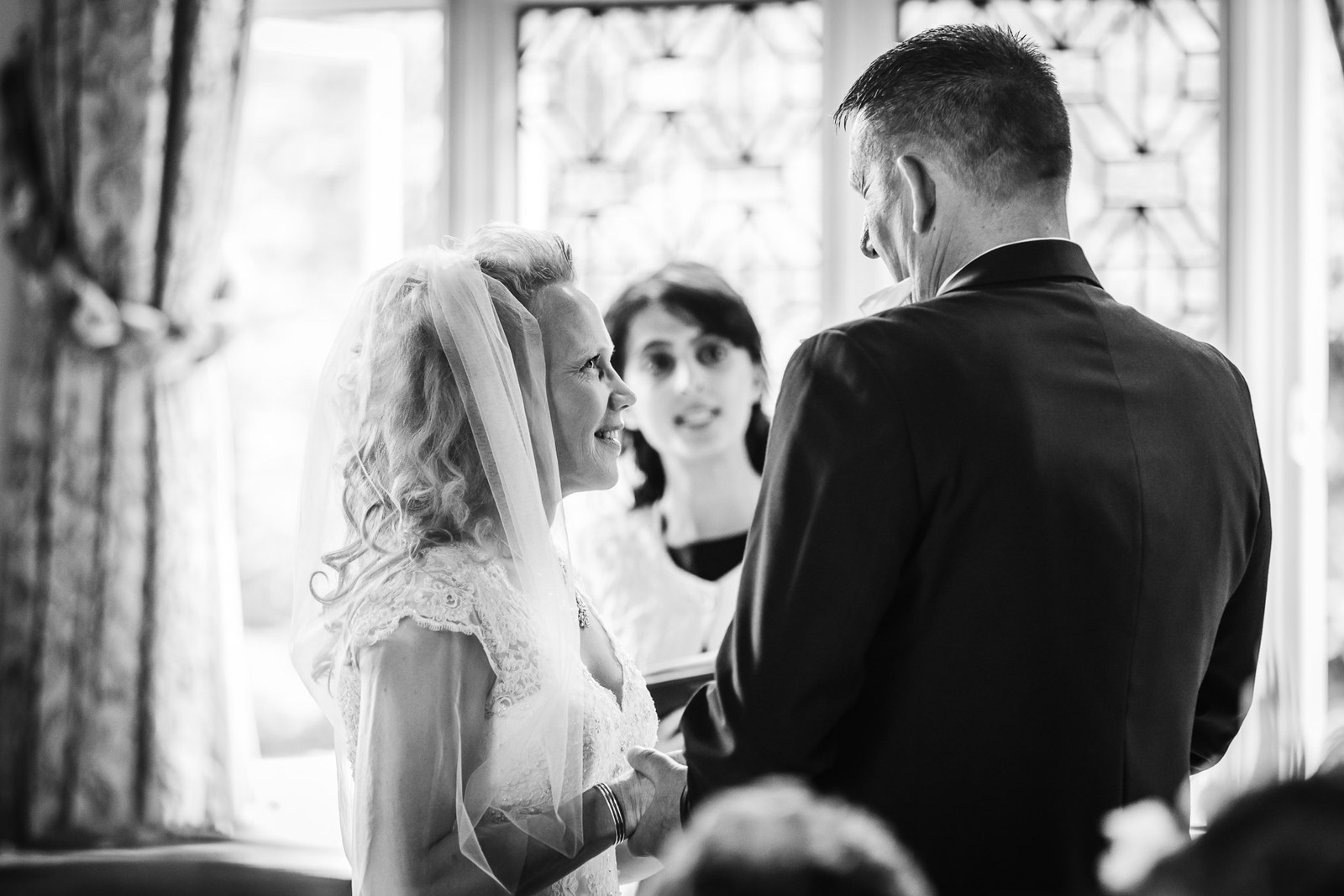 The couple gazing at each other during the ceremony as guests look on
