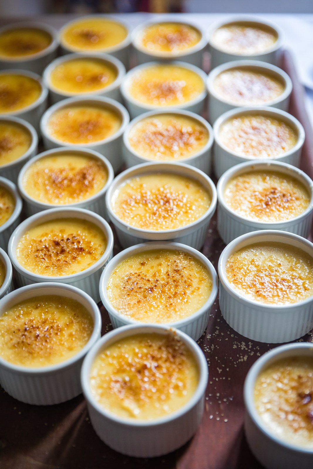 Rows of creme brulee ramekins with caramelised tops