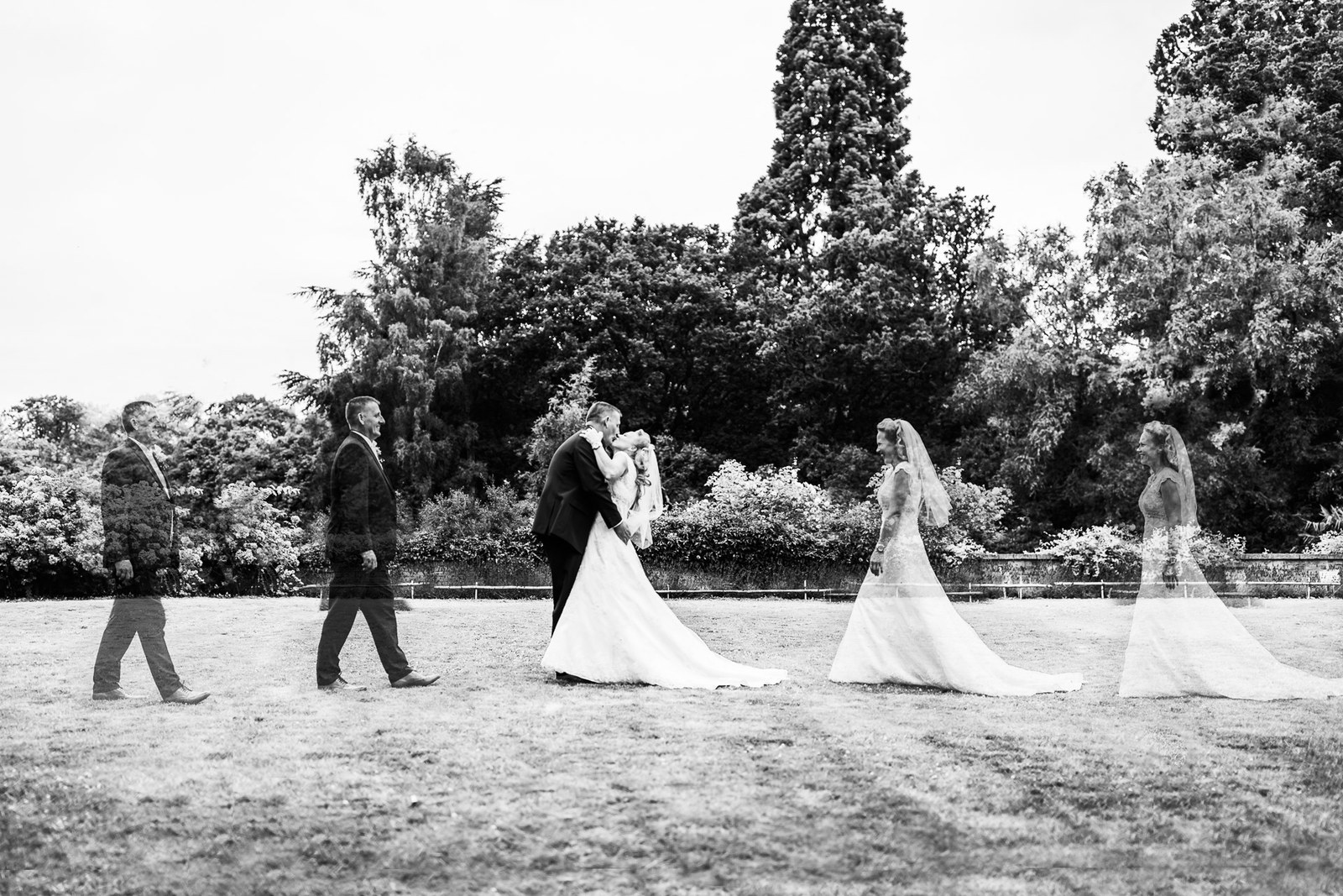 Black-and-white multiple exposure of the couple embracing on the lawn